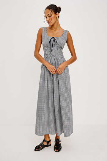 Jordie Maxi Dress in Cotton Poplin With A-Line Silhouette Rounded Square Neckline Rufle Trim Center-Front Bust Cutrout With Self-Ties Smocked Waist Side Pockets and Fully Lined Skirt in Black Gingham Colorway - Full Body Front View Featured on Model