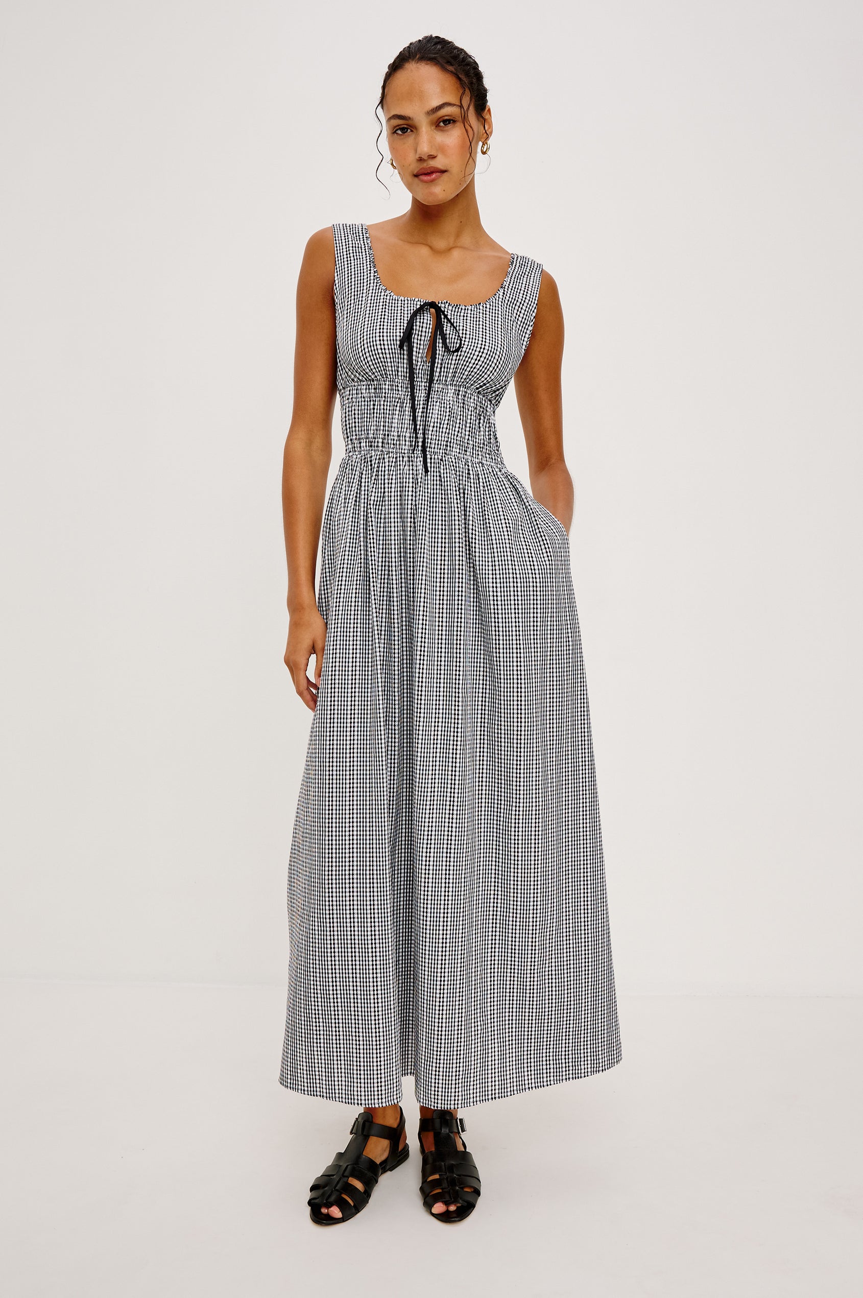 Jordie Maxi Dress in Cotton Poplin With A-Line Silhouette Rounded Square Neckline Rufle Trim Center-Front Bust Cutrout With Self-Ties Smocked Waist Side Pockets and Fully Lined Skirt in Black Gingham Colorway - Full Body Front View Featured on Model