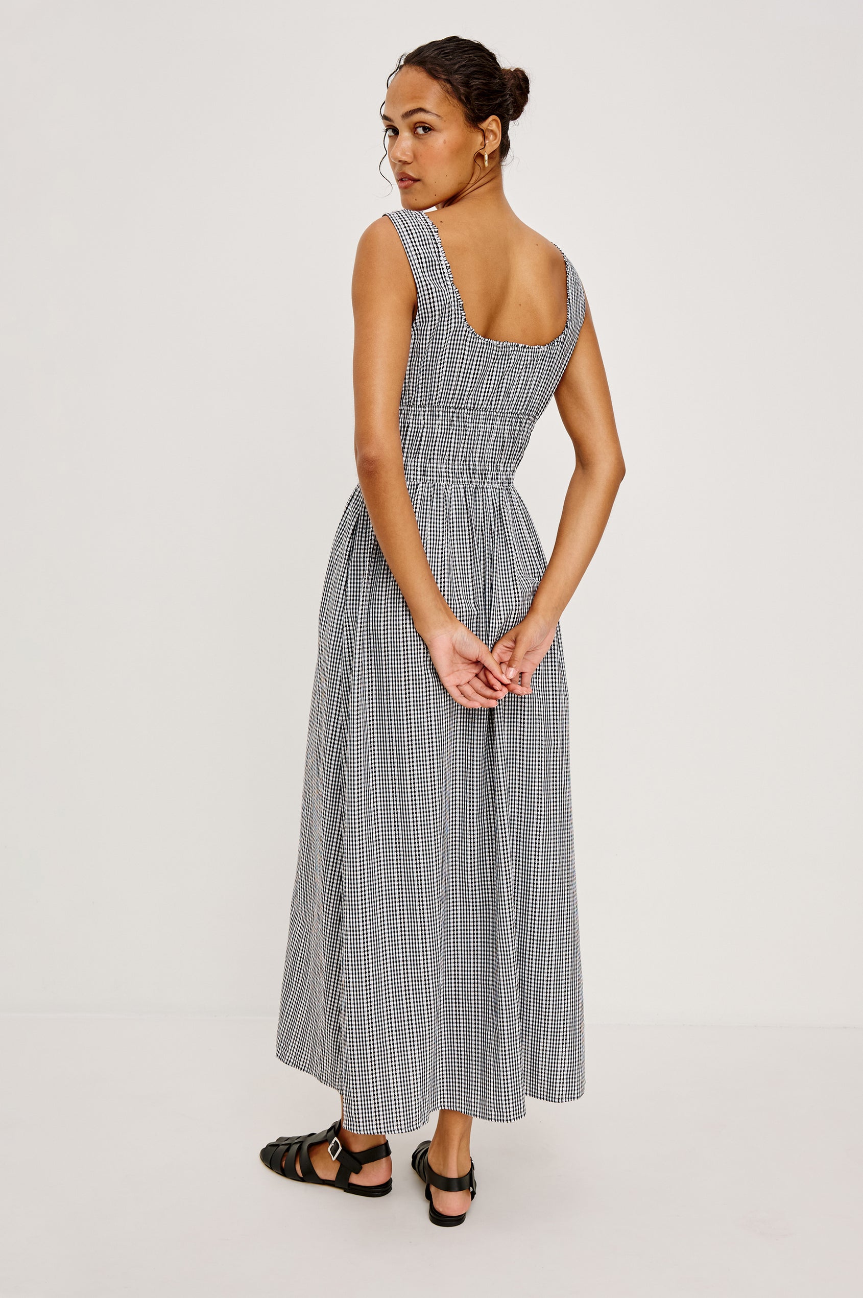 Jordie Maxi Dress in Cotton Poplin With A-Line Silhouette Rounded Square Neckline Rufle Trim Center-Front Bust Cutrout With Self-Ties Smocked Waist Side Pockets and Fully Lined Skirt in Black Gingham Colorway - Full Body Back View Featured on Model