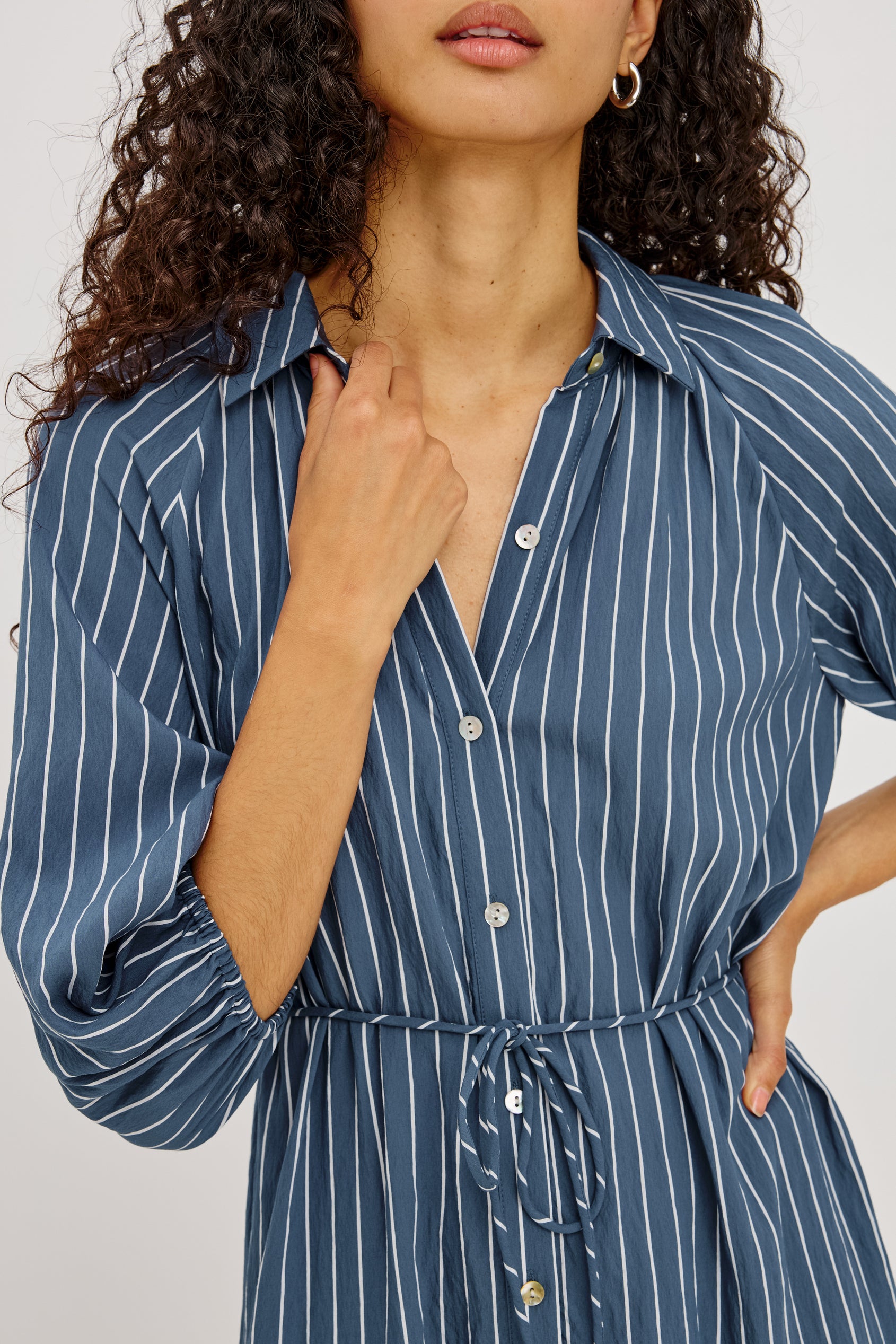 June Maxi Dress in Soft Crinkle Shirting With Three-Quarter Puff Sleeves, Point Collar, Full Front Button Placket, and Self-Tie Waist in Washed Indigo Stripe Colorway - Upper Body Front View Featured on Model