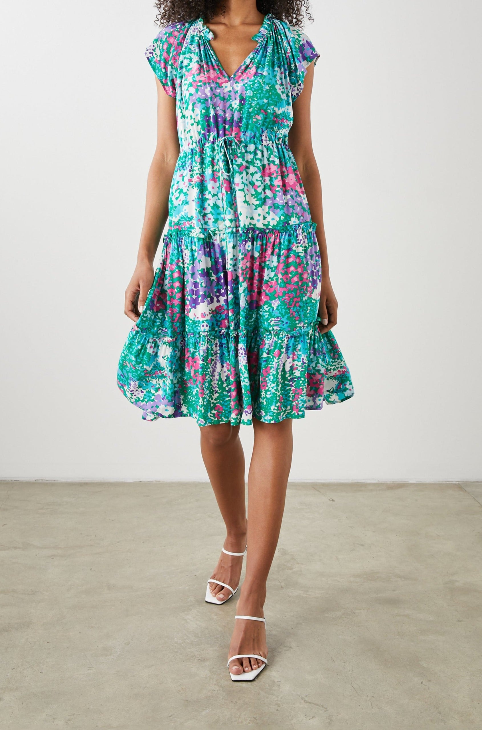 Juni Short Sleeve Midi Dress with a V Neck, Light Ruching along the Neckline, a Drawstring Waist, and a Tiered Skirt in Gardenia Floral Colorway, in Greens, Blues, Purples, Pinks and White - Front View Featured on Model
