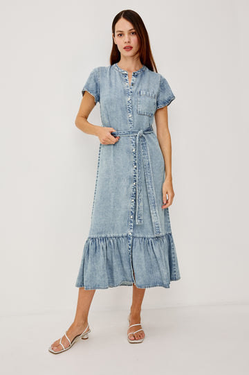 Kahlo TENCELâ„¢ Denim Shirt Dress With Short Flutter Sleeves Front Buttons a Single Chest Patch Pocket Adjustable Belted Ties Ruffle Hem in Faded Indigo Colorway - Full Body Front View Featured on Model