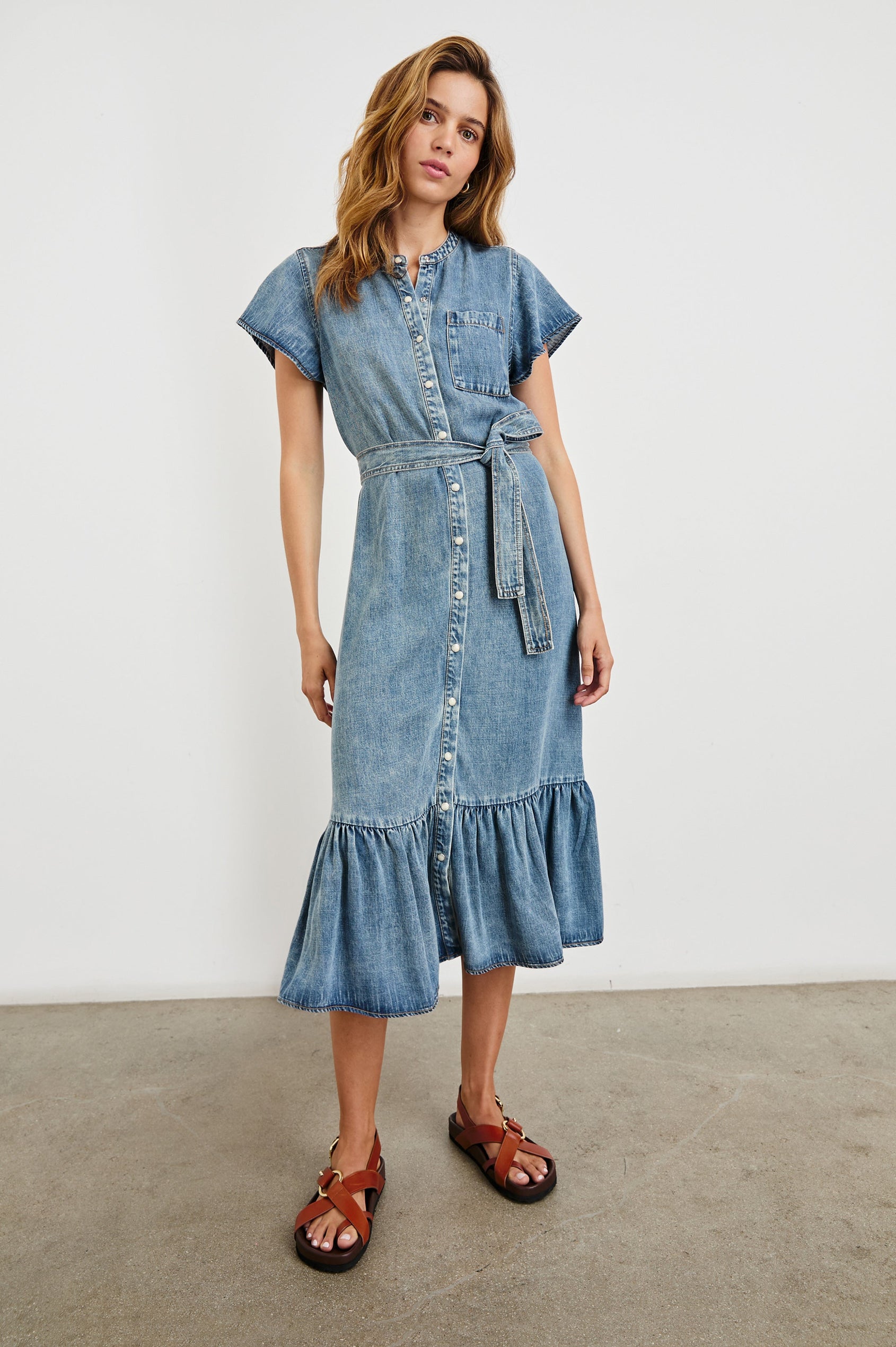 Kahlo Short-Sleeve Midi Dress with Snaps Down the Front, a Waist Tie, a Chest Patch Pocket and a Pleated Hem in Mid Blue Colorway - Front Full Body View Featured on Model