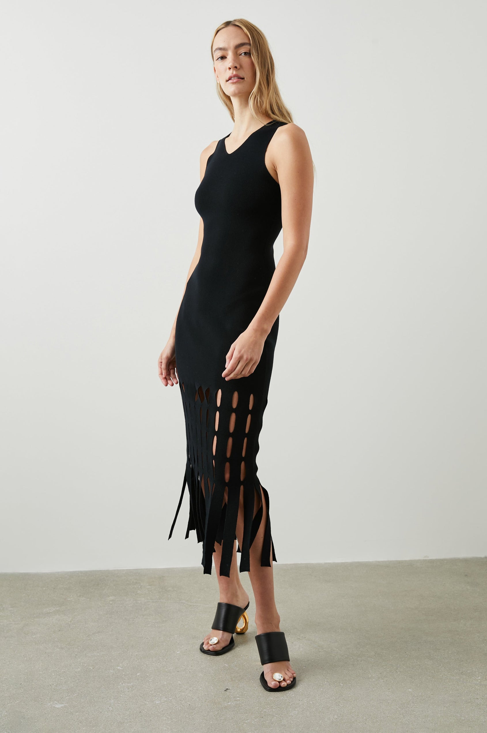 Kaia Sleeveless Midi Dress with a V Neck and Vertical Dashed Cutouts From the Thigh Downward, ending in Panels in Black Colorway - Front Full Body View Featured on Model