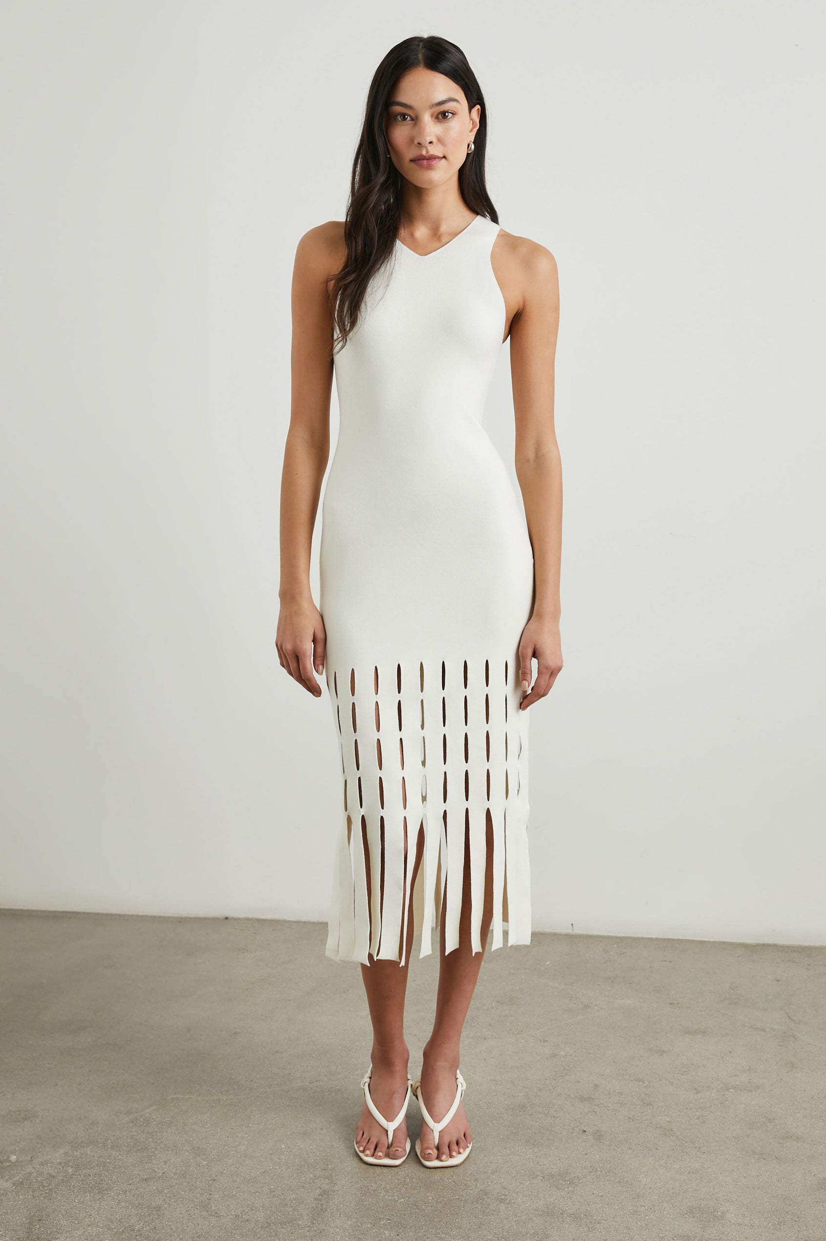 Kaia Sleeveless Midi Dress with a V Neck and Vertical Dashed Cutouts From the Thigh Downward, ending in Panels in White Colorway - Front Full Body View Featured on Model