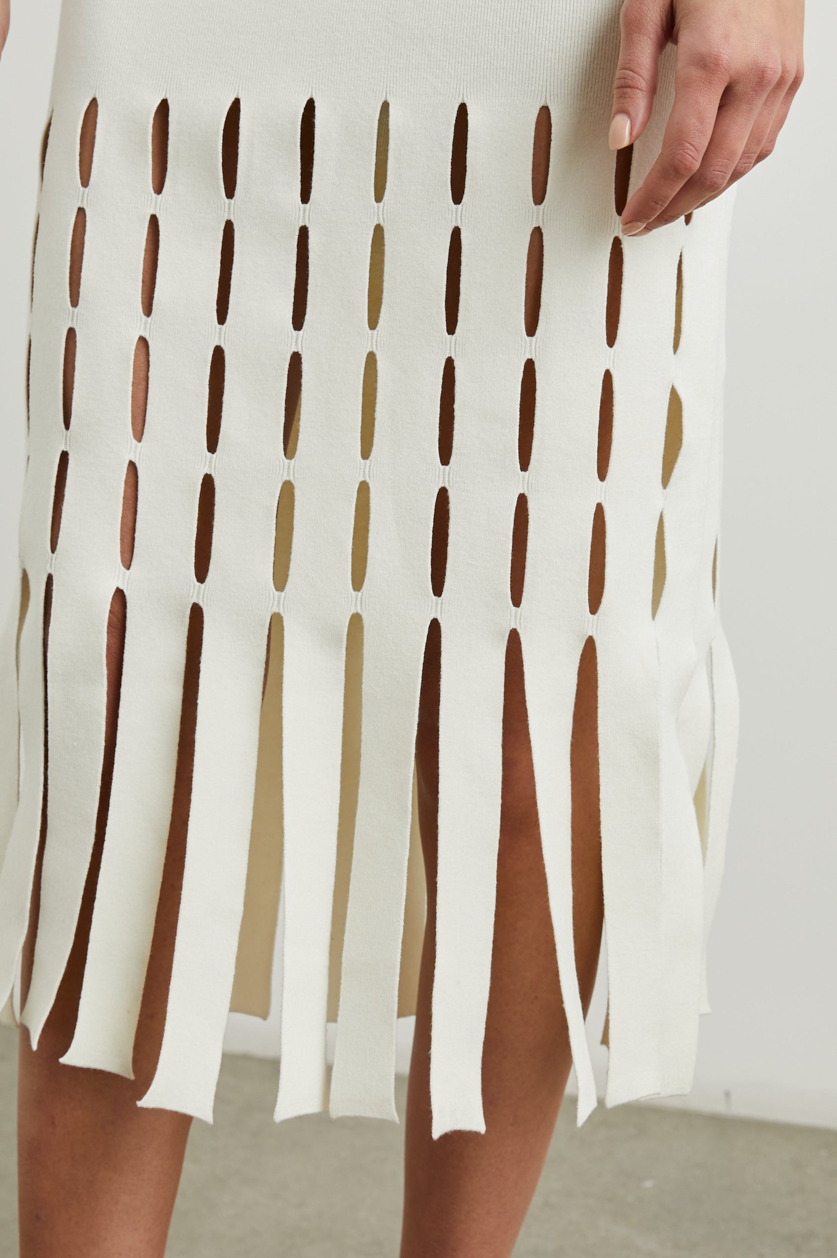 Kaia Sleeveless Midi Dress with a V Neck and Vertical Dashed Cutouts From the Thigh Downward, ending in Panels in White Colorway - Front View Featured on Model