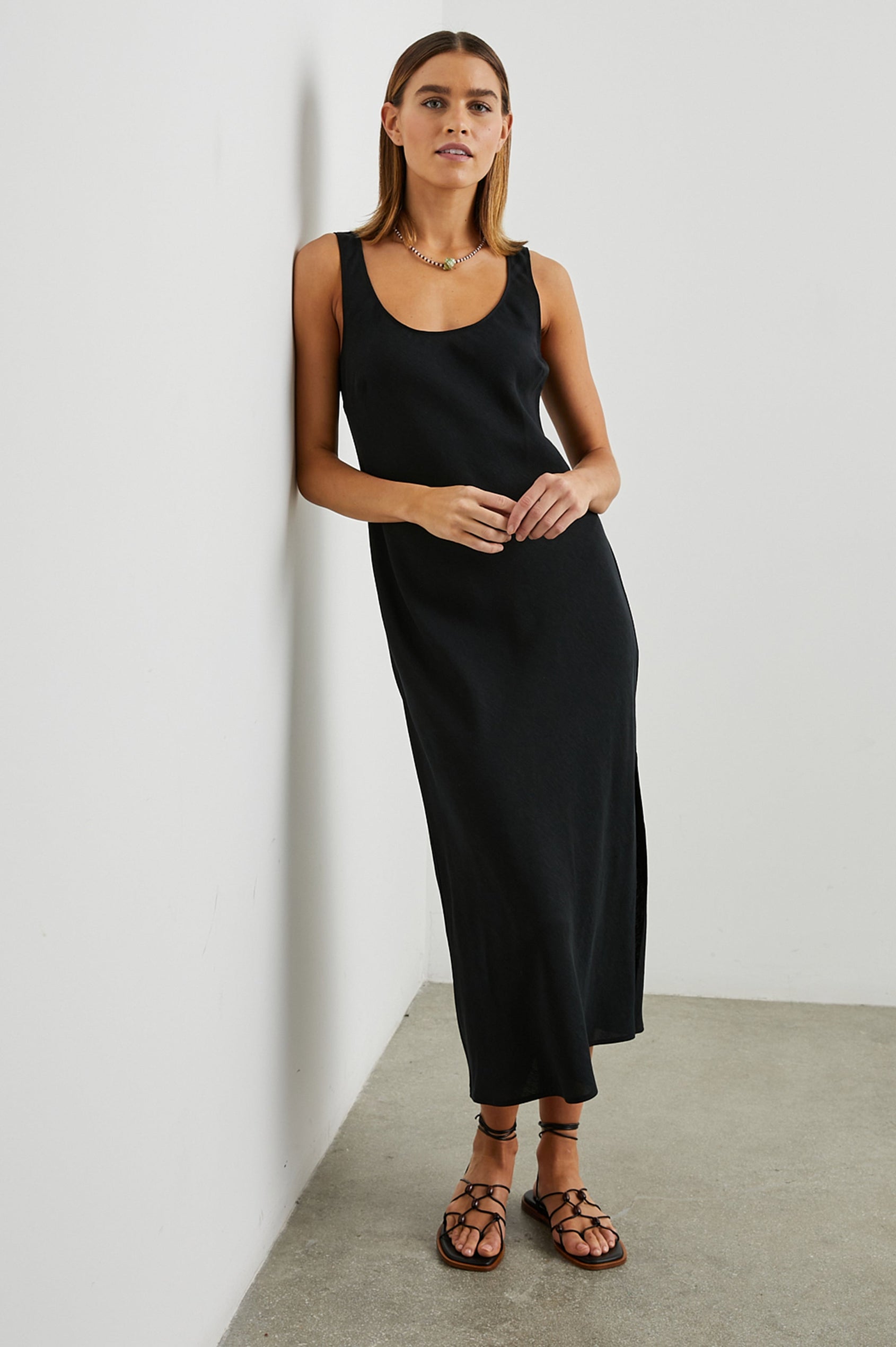 Kailani Sleeveless Midi Dress with Shoulder Straps, a Scoop Neck and Side Slit to the Knee in Black Colorway - Front Full Body View Featured on Model