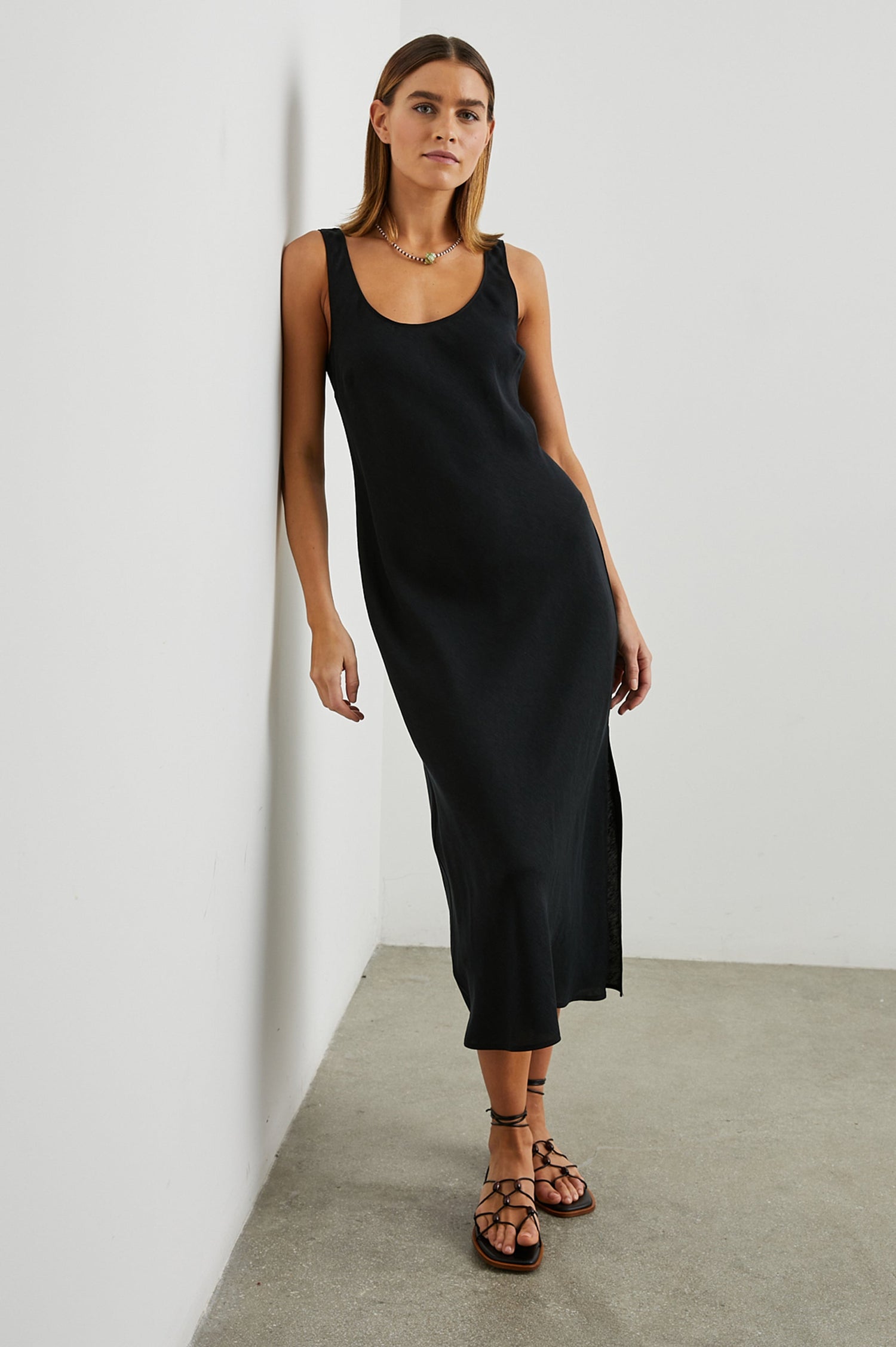 Kailani Sleeveless Midi Dress with Shoulder Straps, a Scoop Neck and Side Slit to the Knee in Black Colorway - Front Full Body View Featured on Model