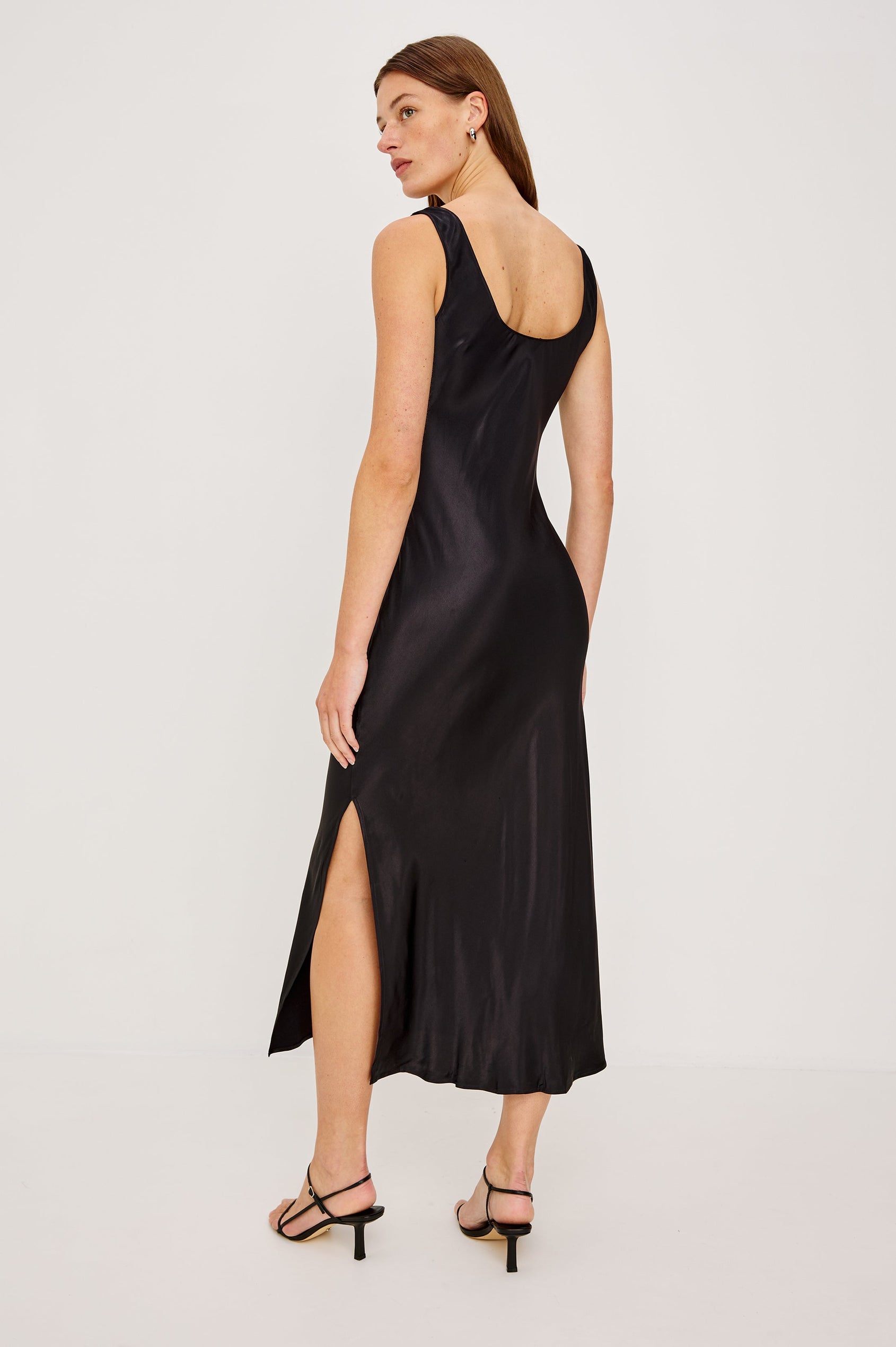 Kailani Sleeveless Midi Dress with Shoulder Straps, a Scoop Neck and Side Slit to the Knee in Black Satin Crepe Colorway -Back Full Body View Featured on Model