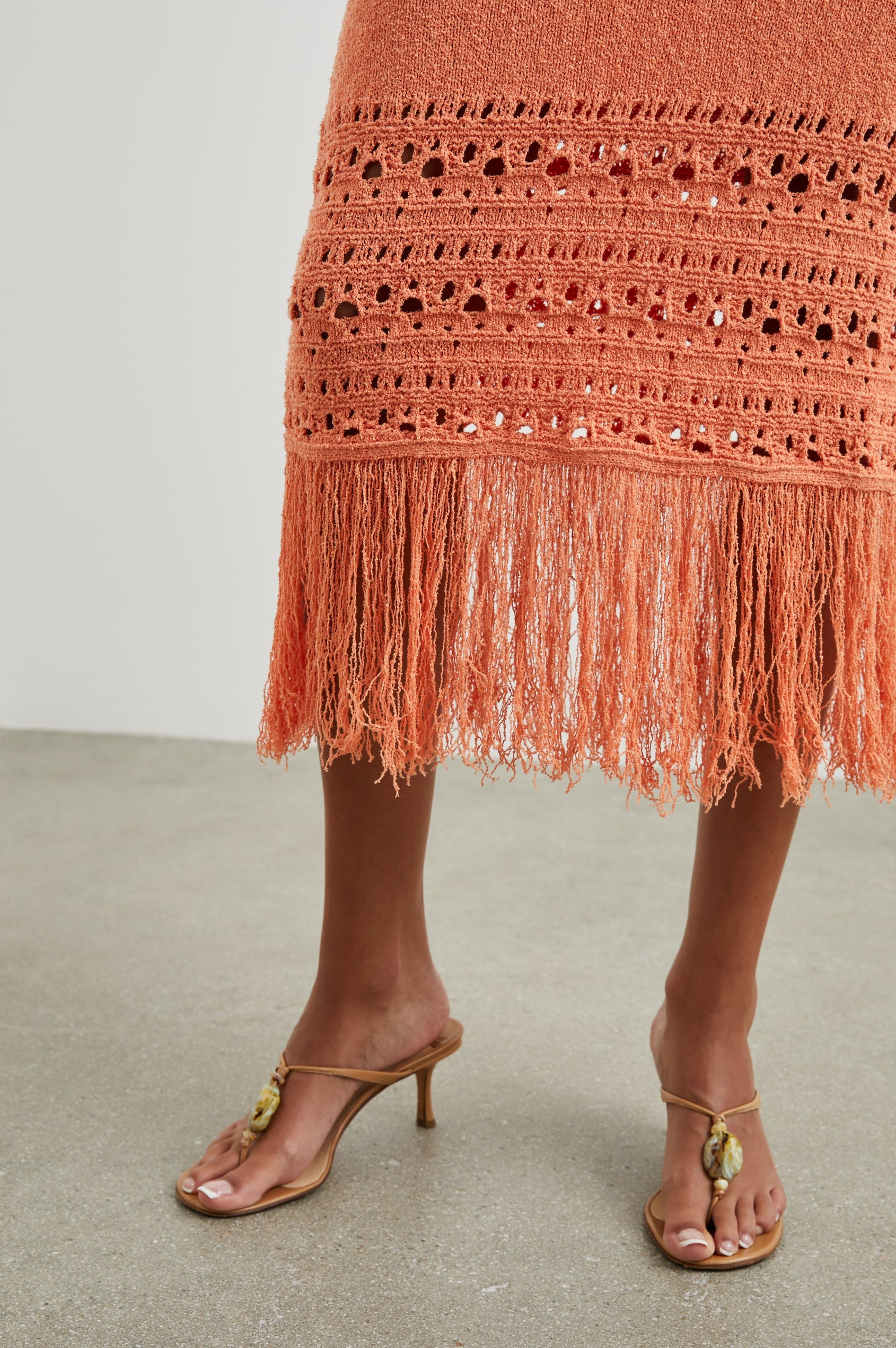 Kaja Midi Skirt with a Crochet Design Along the Bottom and Fringe at the Hem in Persimmon Colorway - Front View Featured on Model  