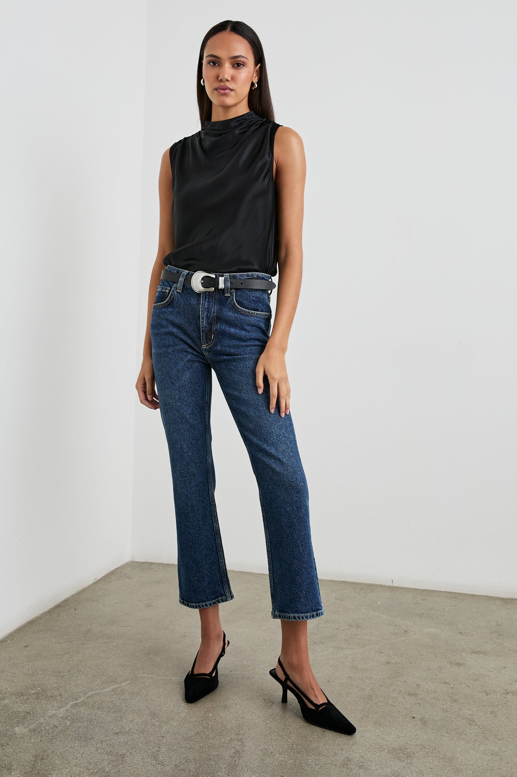 Kaleen Sleeveless Top with Mock Neck with Buttons and Keyhole on the Back and Draped Fabric on the Upper Chest in Ivory Colorway- Front Tucked Full Body View Featured on Model