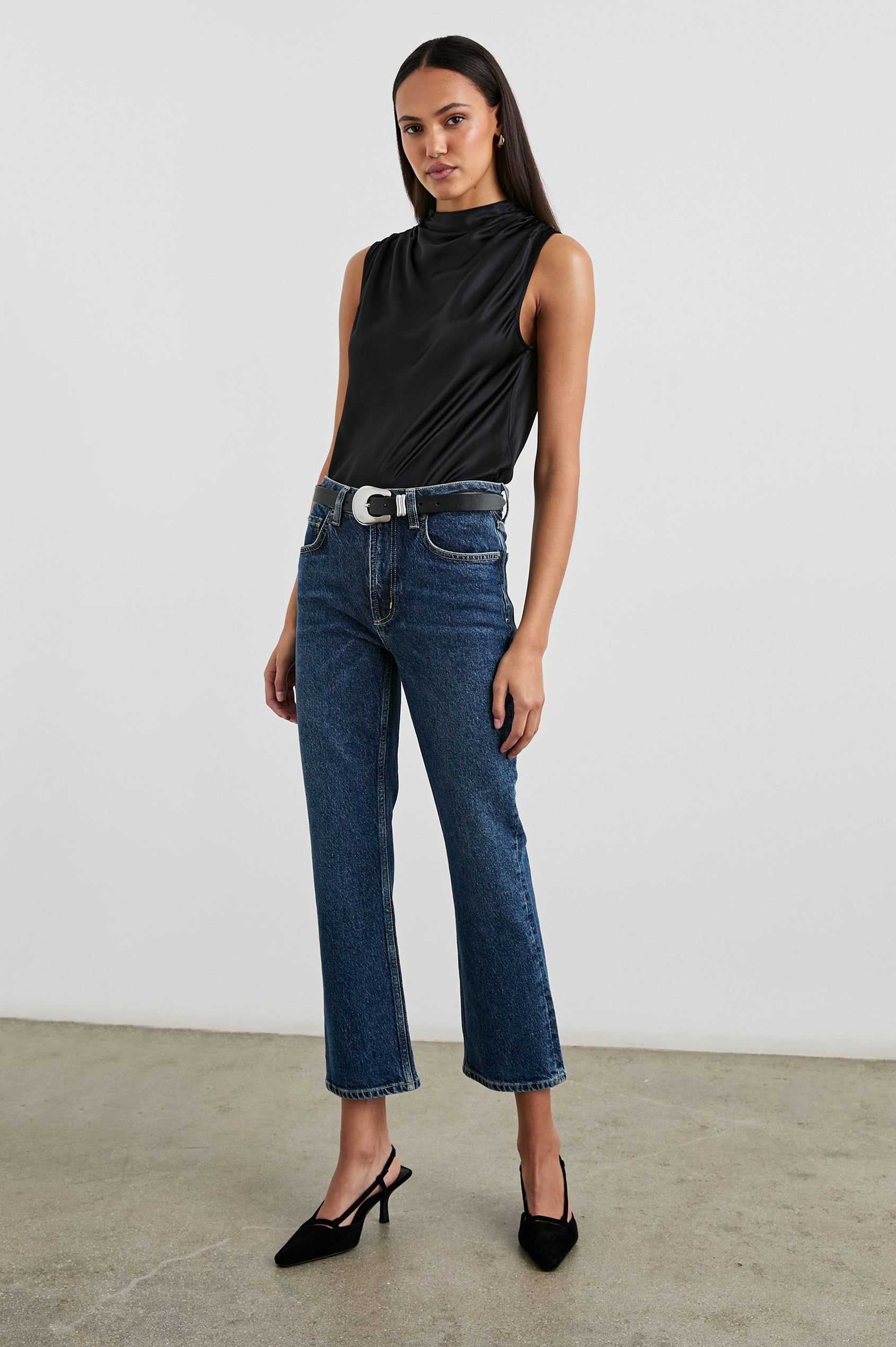 Kaleen Sleeveless Top with Mock Neck with Buttons and Keyhole on the Back and Draped Fabric on the Upper Chest in Ivory Colorway- Front Tucked Full Body View Featured on Model