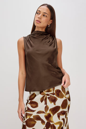 Kaleen Sleeveless Top with Mock Neck with Buttons and Keyhole on the Back and Draped Fabric on the Upper Chest in Espresso Colorway - Front Untucked View Featured on Model