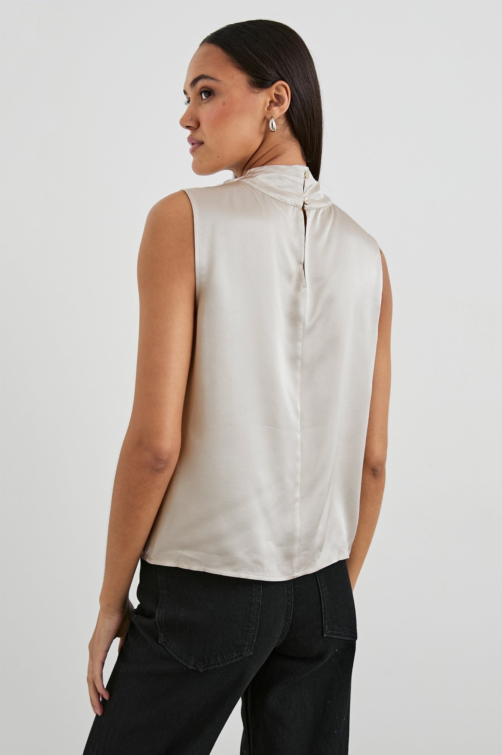 Kaleen Sleeveless Top with Mock Neck with Buttons and Keyhole on the Back and Draped Fabric on the Upper Chest in Ivory Colorway- Back View Featured on Model