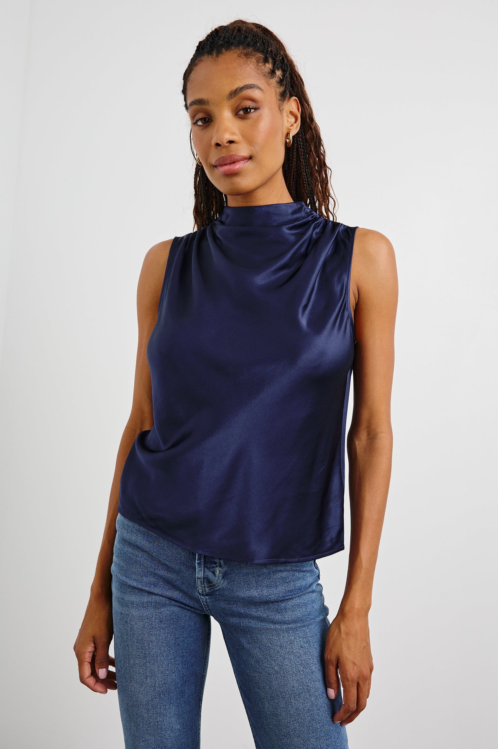 Kaleen Sleeveless Top with Mock Neck with Buttons and Keyhole on the Back and Draped Fabric on the Upper Chest in Navy Colorway - Front View Featured on Model