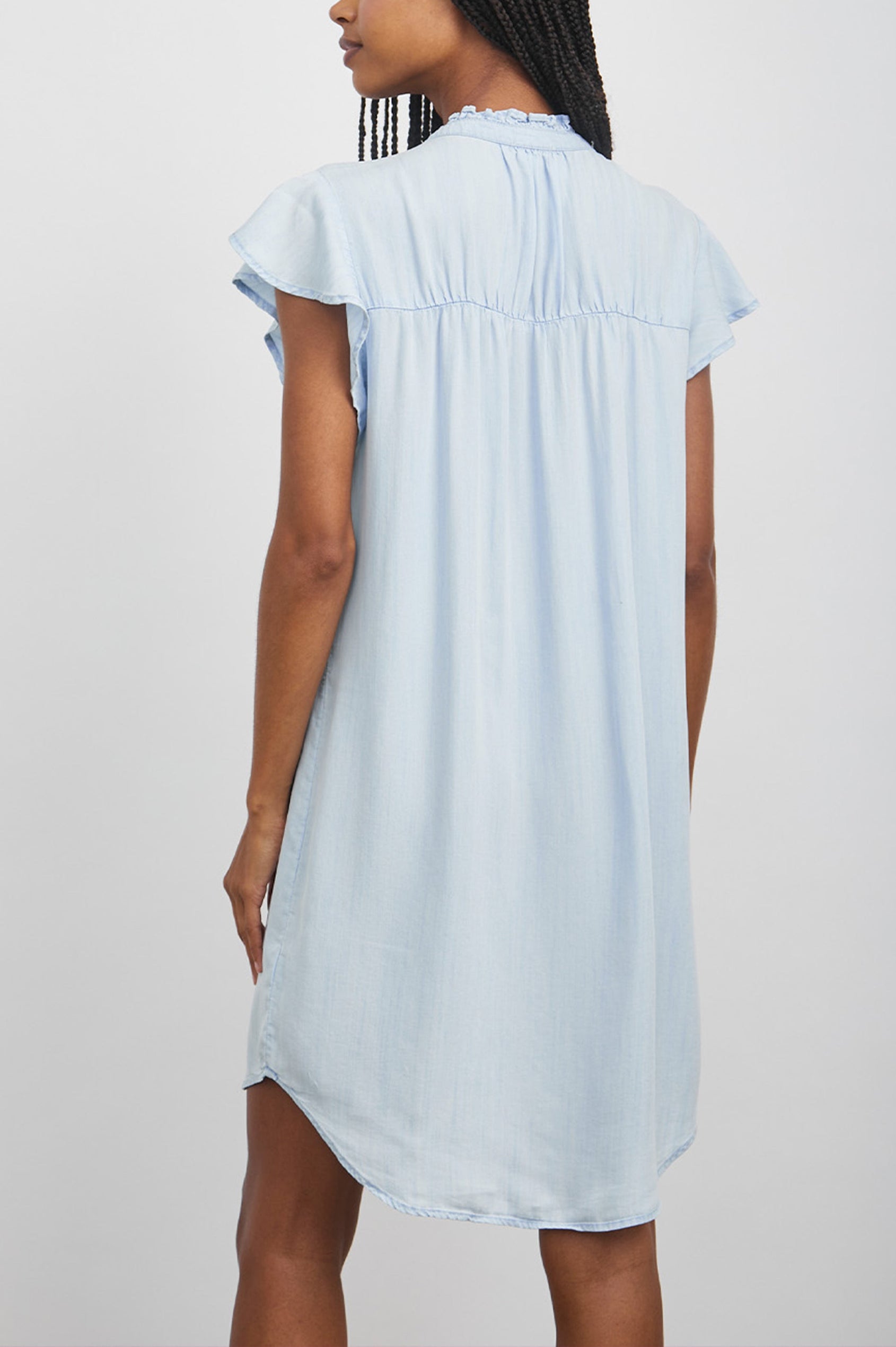Kat Short Sleeve, Above the Knee Denim Dress with Buttons Down the Front, a Ruffled Collar and Flutter Sleeves in Light Vintage Colorway - Back Full Body View Featured on Model 