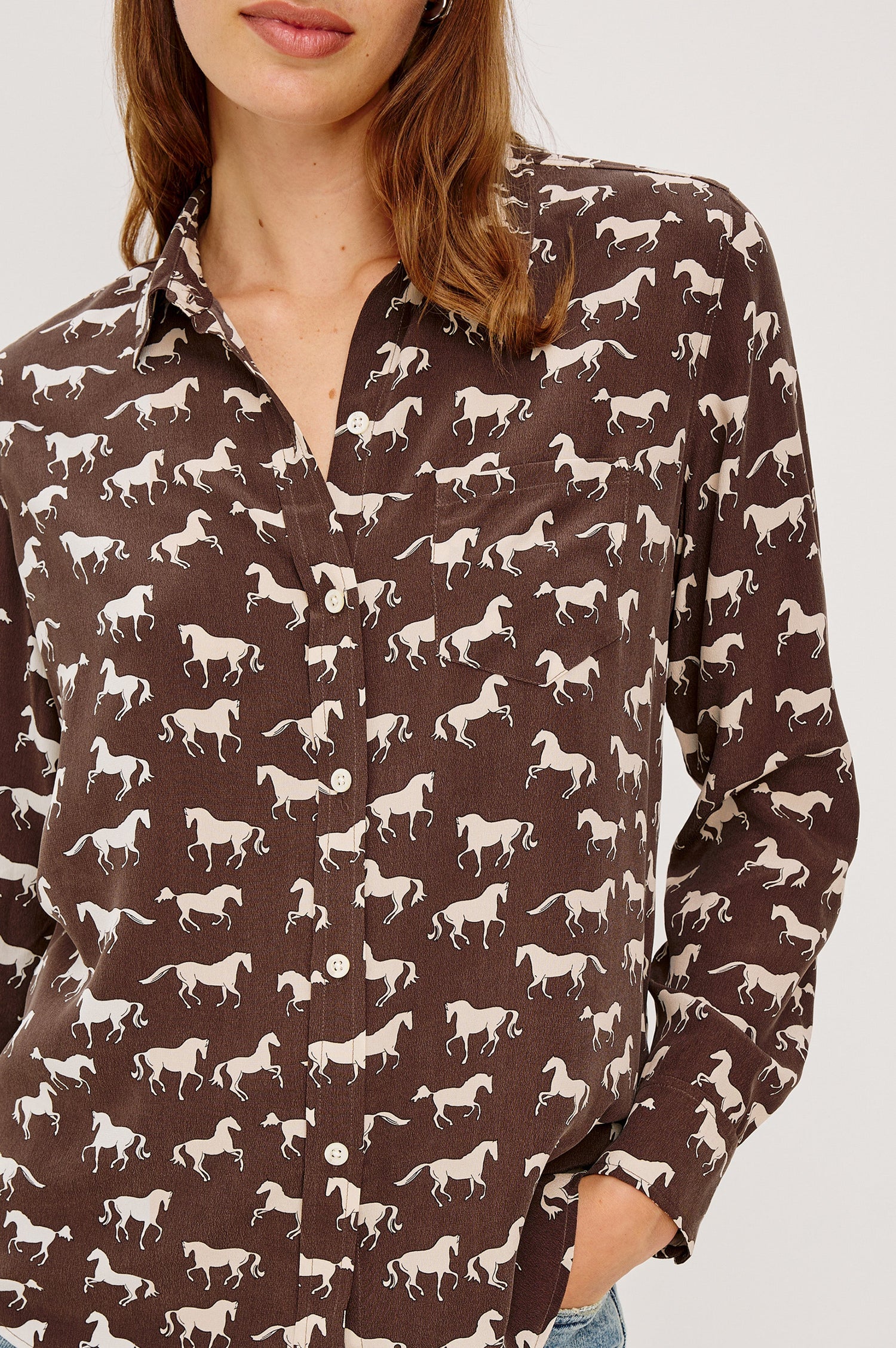 Washed silk button-down shirt in ivory with a horse print. The shirt has a soft drape and classic collar for a polished look. Close Up View on Model.
