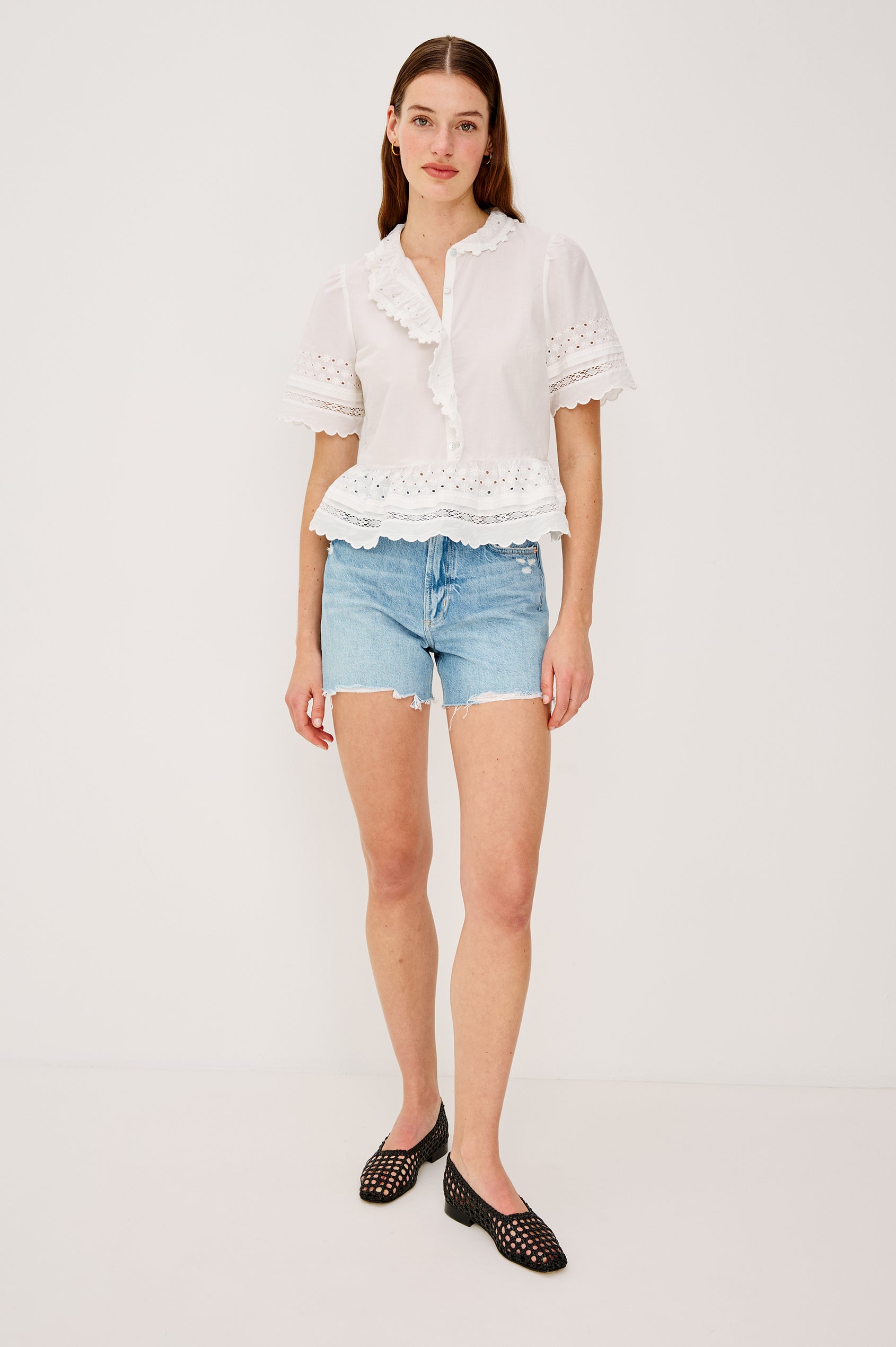 Keeta Shirt in Lightweight Beach Cotton With Ruffled Peter Pan Collar Front Placket Short Sleeves Tiered Hem Crochet Eyelet and Scalloped Trim in White Colorway - Full Body Front View Featured on Model