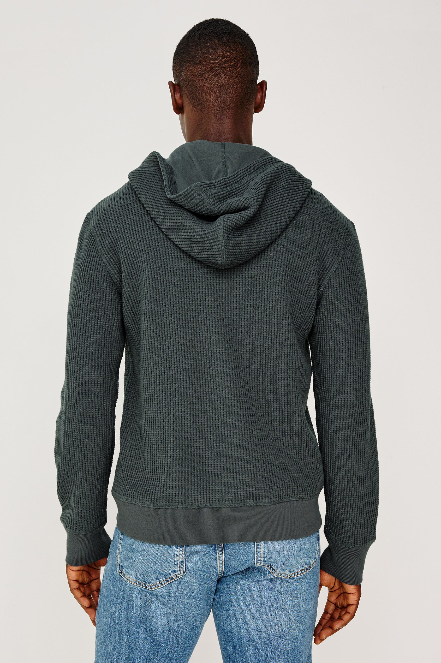 Kenton is a zip front hooded sweatshirt with front patch pockets and ribbed cuffs in Ink colorway. Back view featured on model.