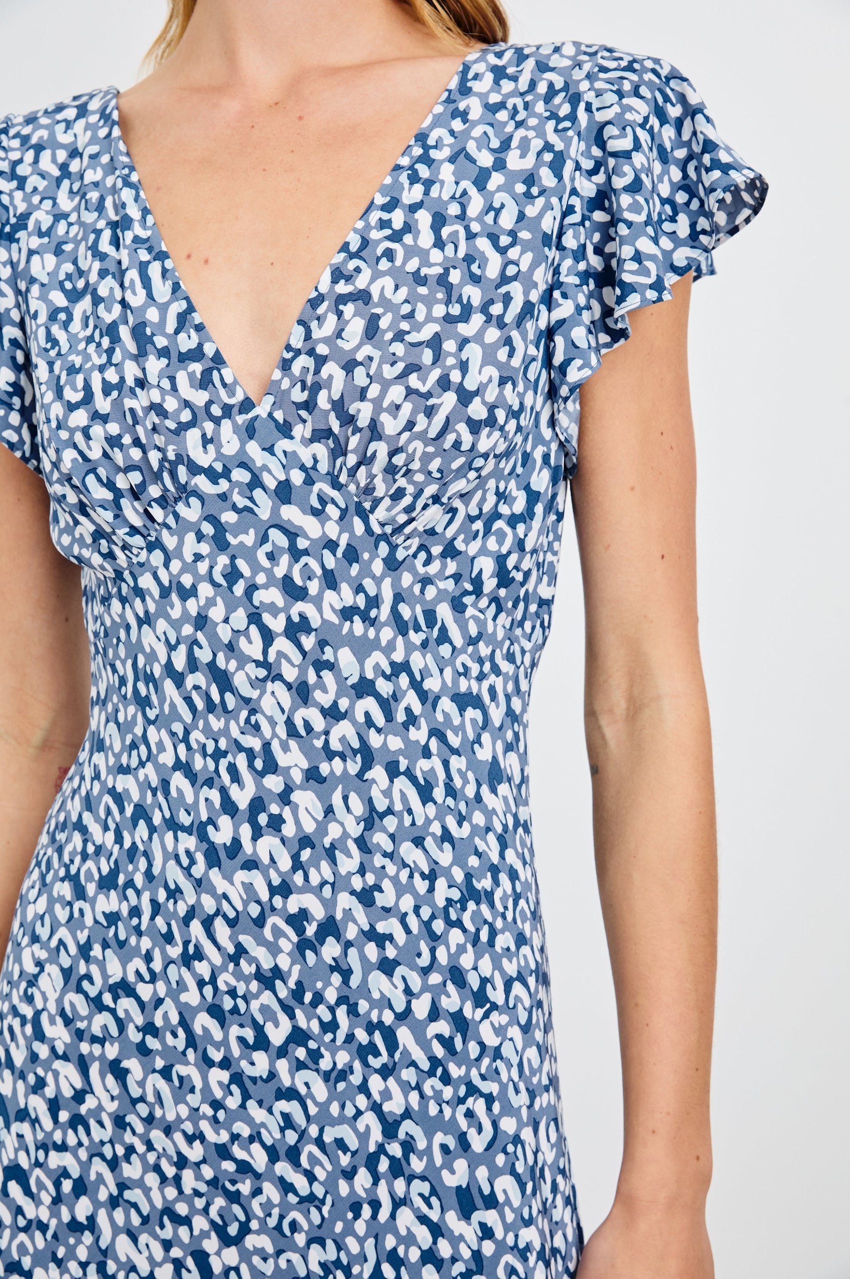 Kenz Midi Dress with Flutter cap Sleeves, and a deep V Neck in Blue Mixed Cheetah Colorway, Spots in Blues and White - Front View Featured on Model