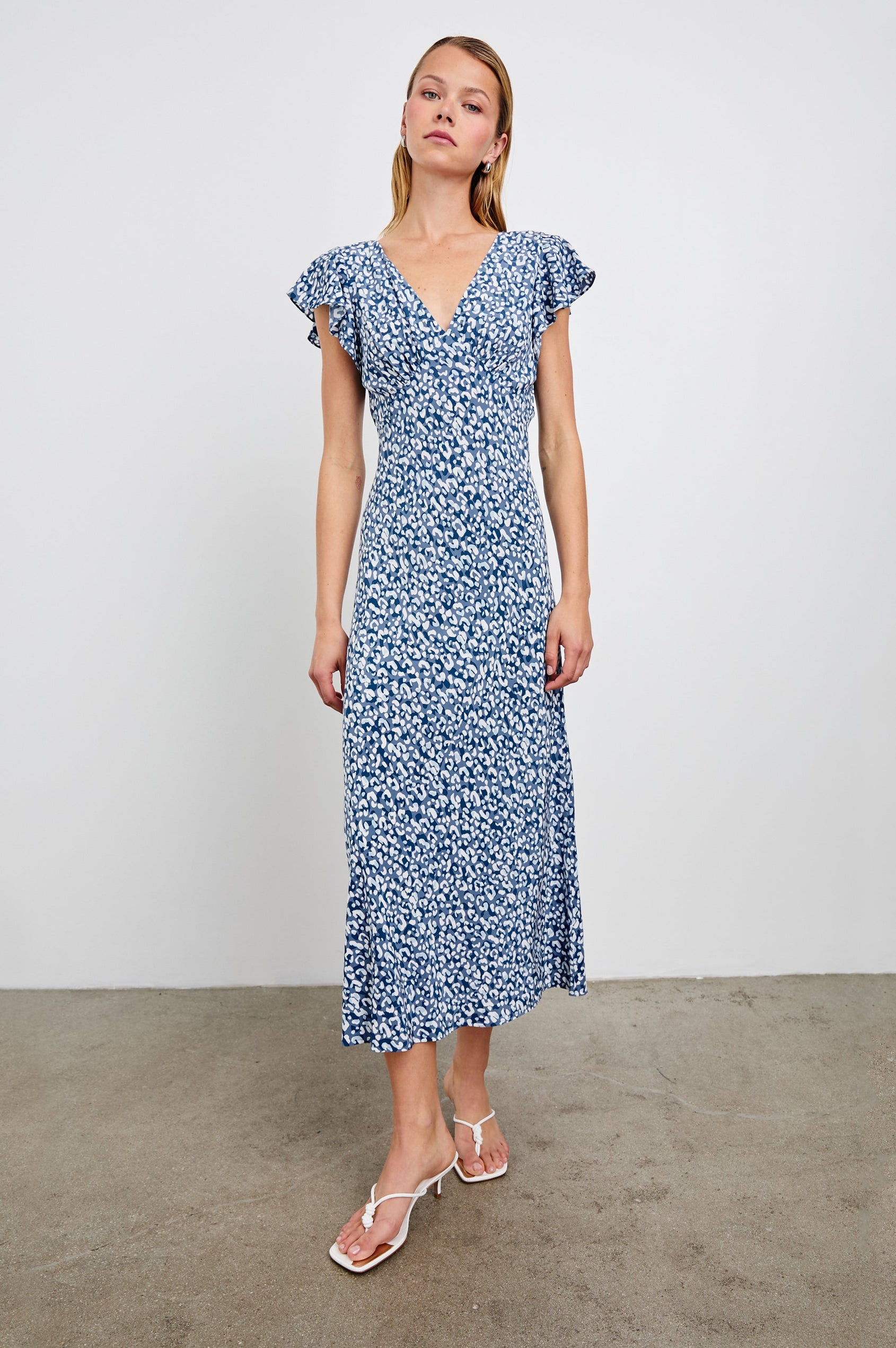Kenz Midi Dress with Flutter cap Sleeves, and a deep V Neck in Blue Mixed Cheetah Colorway, Spots in Blues and White - Front Full Body View Featured on Model