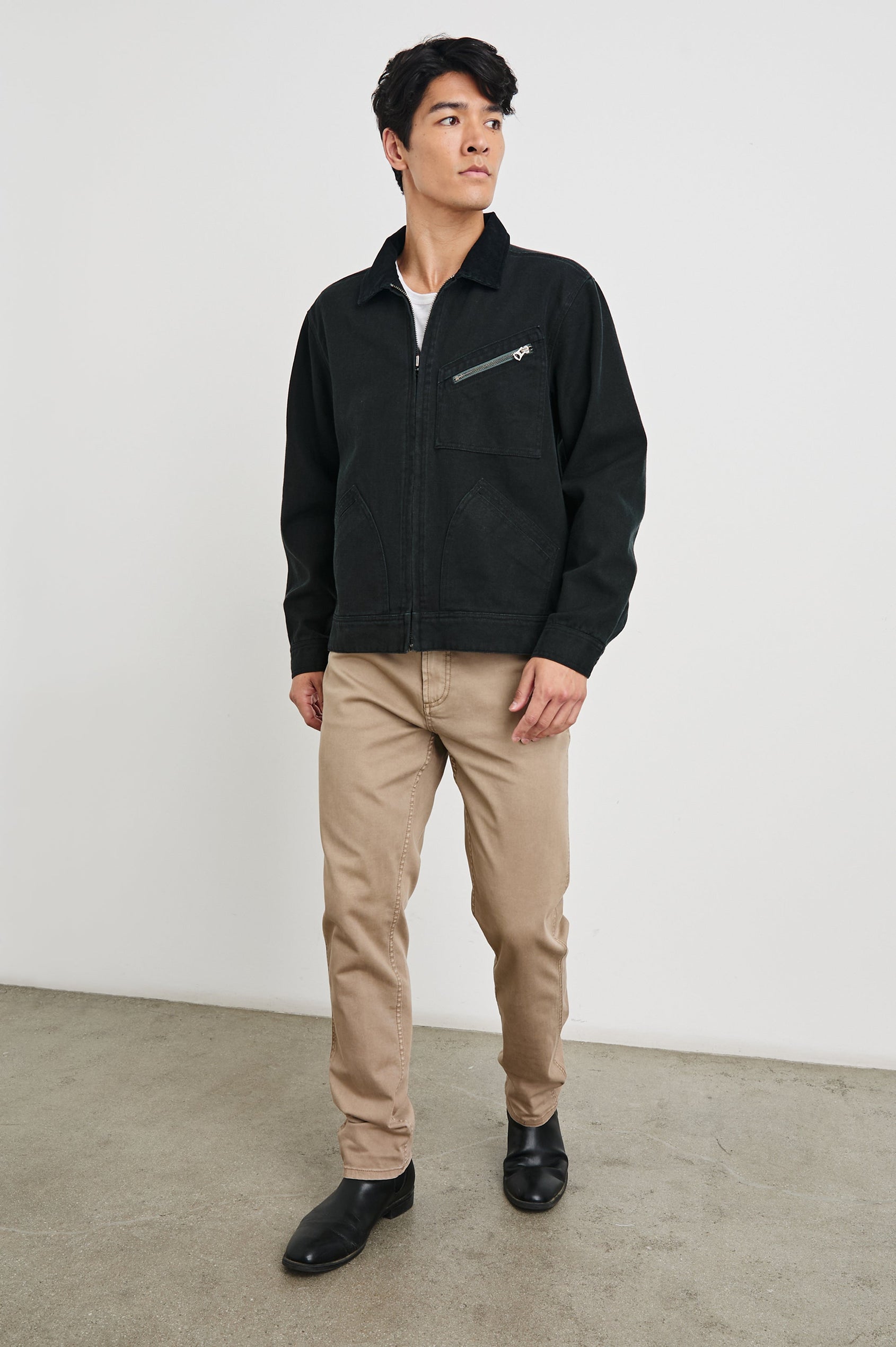 Ketter Zip Up Jacket with Two Curved Front Patch Pockets, a Diagonally Zippered Chest Patch Pocket and Adjustable Button Straps on the Hem in Raven Colorway - Front Full Body View Featured on Model