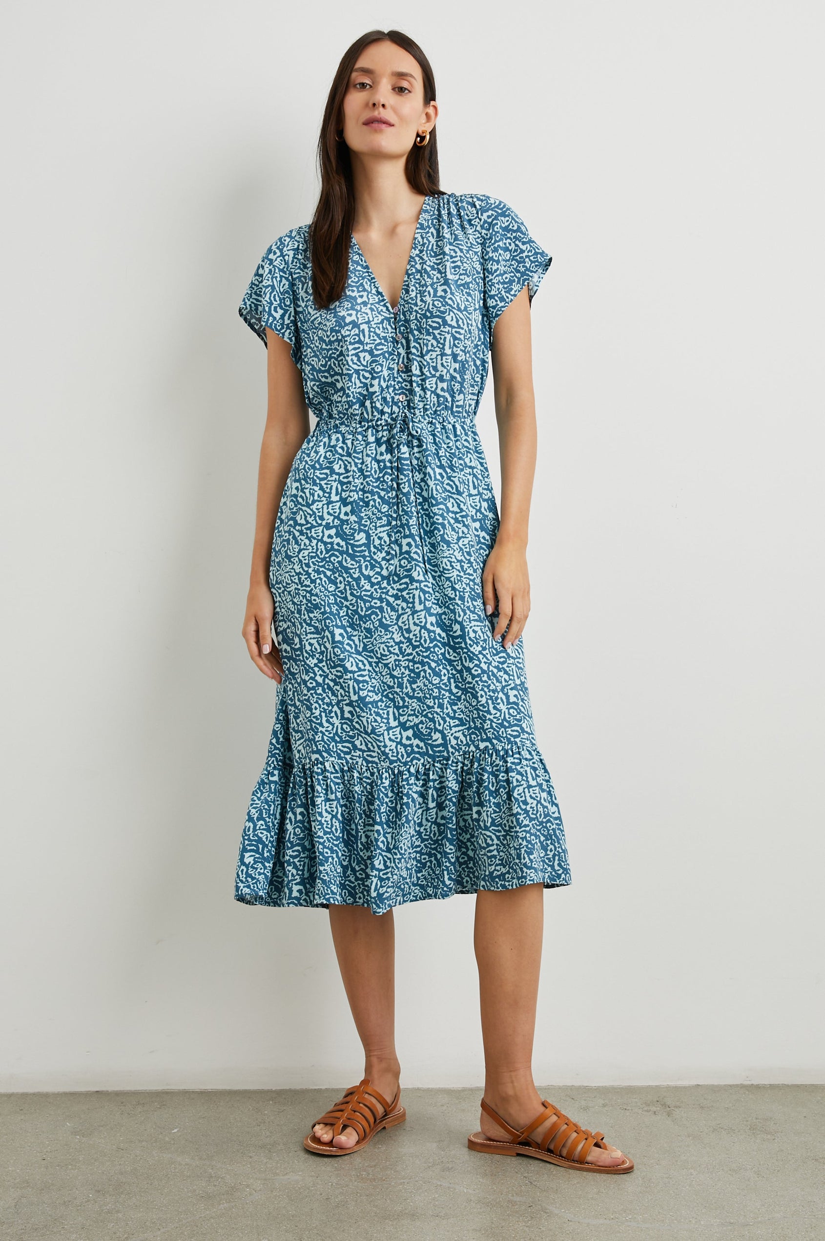 Kiki Short Sleeve Midi Dress with a V Neck, Buttons Down the Front Bodice, a Drawstring Waist and Ruffles at the Hem in Blue Havana Colorway, a Print in Blues - Front Full Body View Featured on Model 