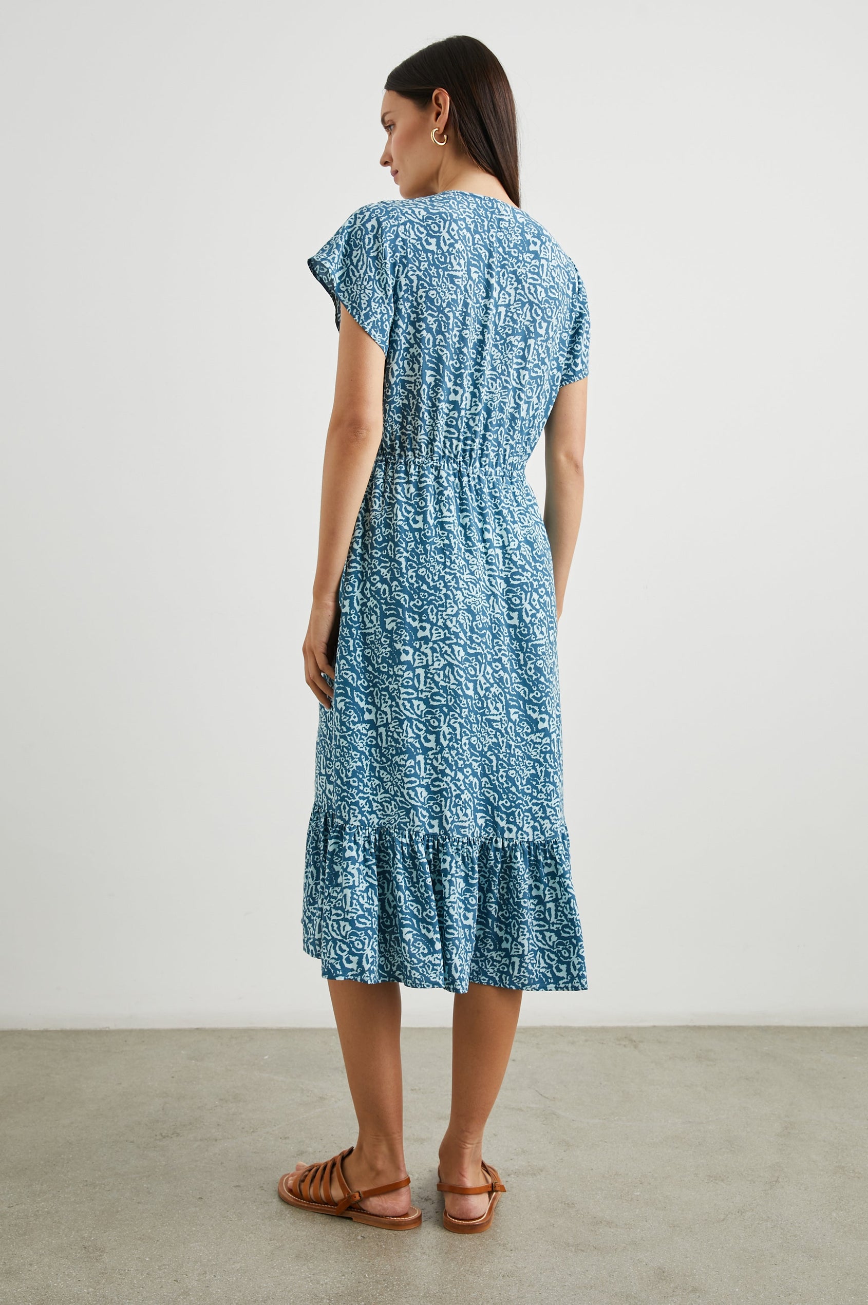Kiki Short Sleeve Midi Dress with a V Neck, Buttons Down the Front Bodice, a Drawstring Waist and Ruffles at the Hem in Blue Havana Colorway, a Print in Blues - Back Full Body View Featured on Model 