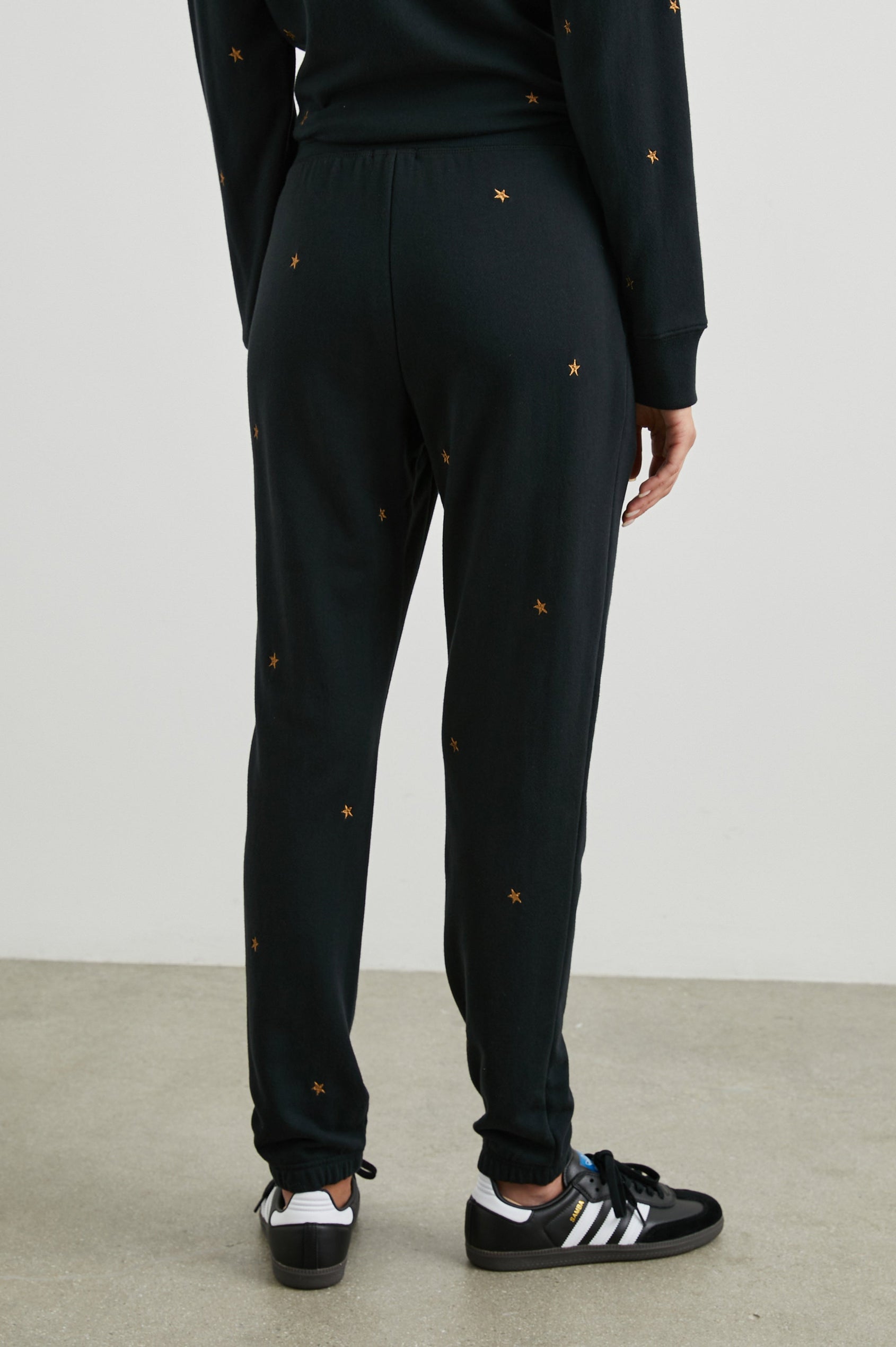 Kingston Sweatpants with Elastic Cuffs and Waist with Drawcord in Bronze Star Embroidery Colorway, Bronze Stars on Black - Back View Featured on Model