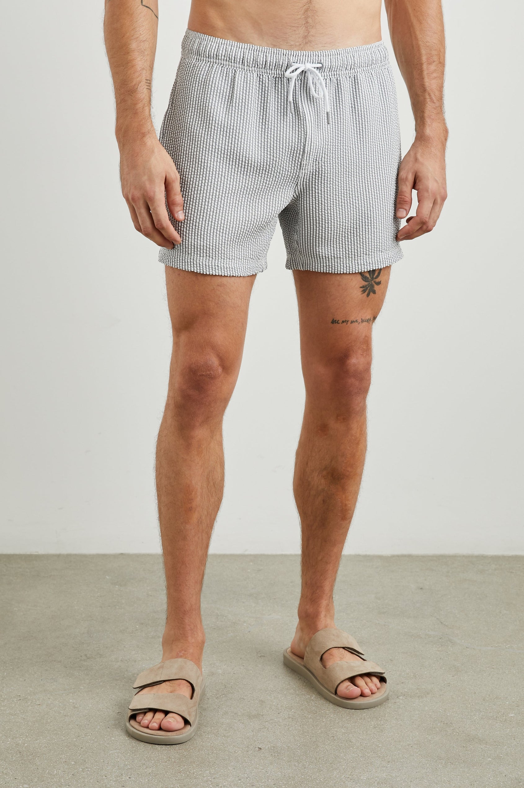 La Brea Swim Shorts with a Drawstring Waist, Two Front Pockets and a Back Patch Pocket in Faded Seersucker Colorway,  Grey and white thin vertical stripes - Front View Featured on Model