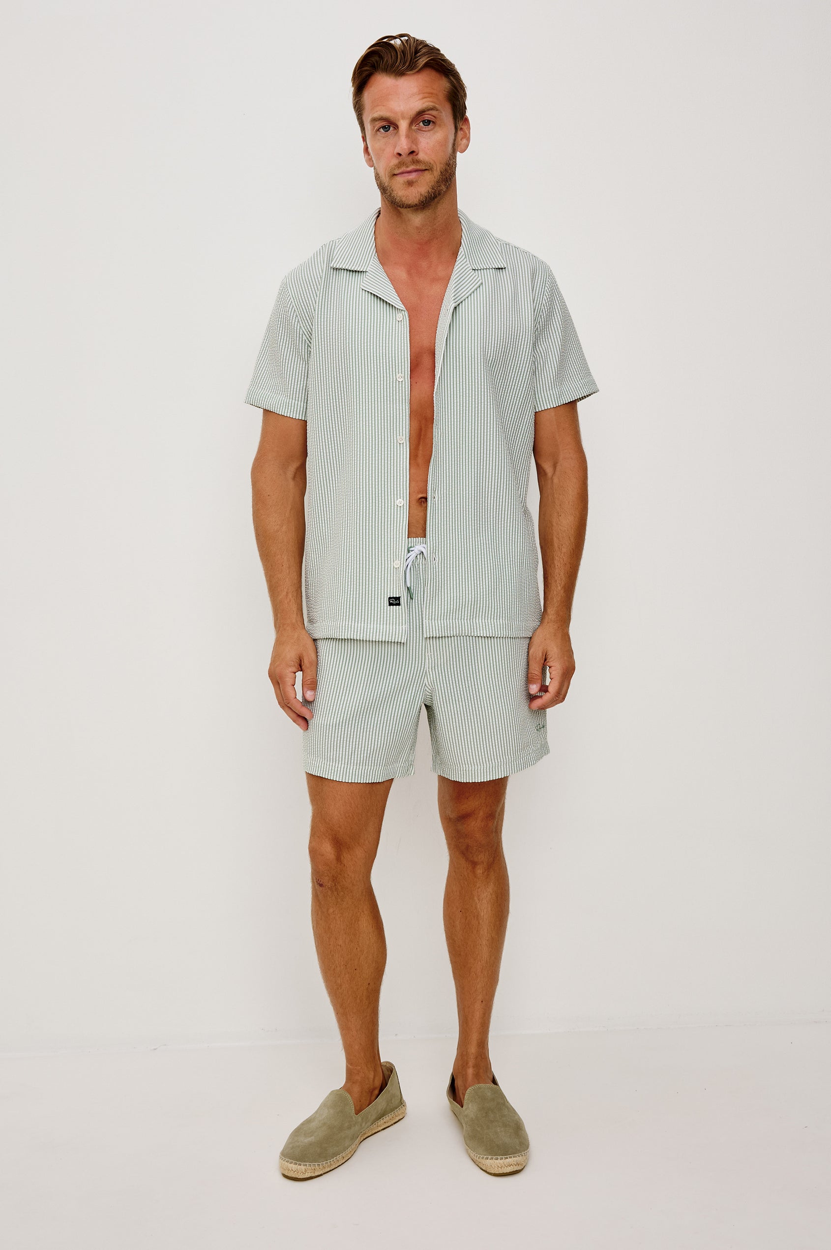 The Amalfi Button-Up Short Sleeve Shirt in Lightweight Stretch Linen-Blend With a Notched Collar and Classic Fit in Sage White Seersucker - Full Body Front View Featured on Model