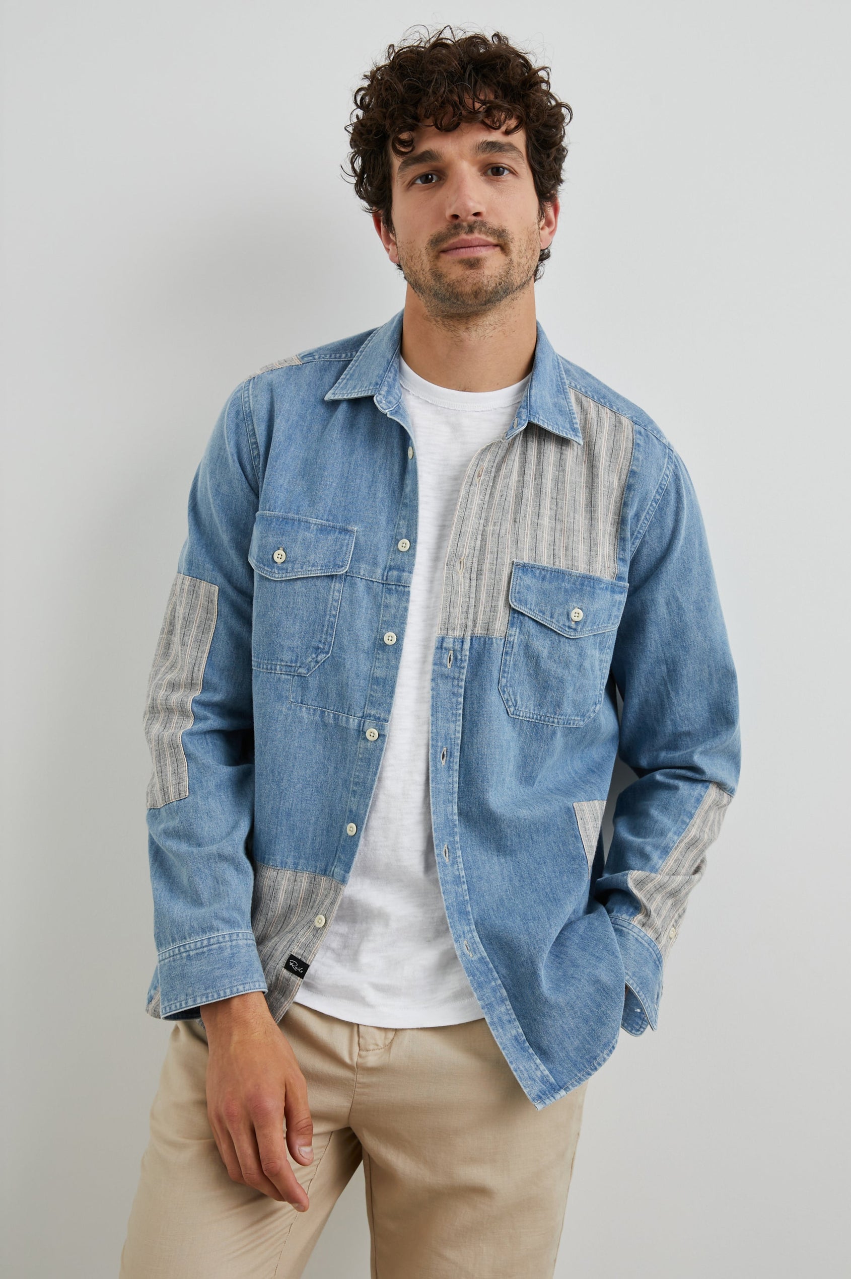 Larsen Long-Sleeve Button Up with Two Chest Button Flap Pockets in Medium Indigo Patchwork Colorway, Denim Patches and Vertical Stripes in Grey and White - Front Unbuttoned View Featured on Model