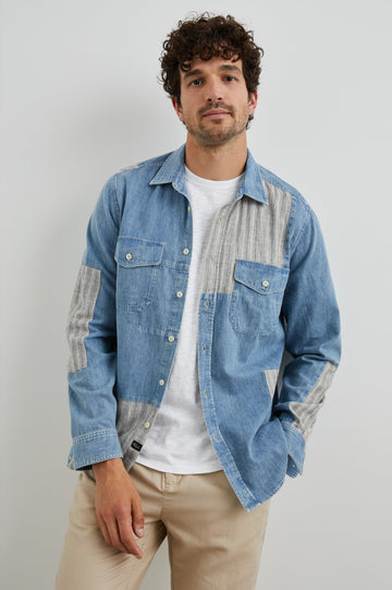 Larsen Long-Sleeve Button Up with Two Chest Button Flap Pockets in Medium Indigo Patchwork Colorway, Denim Patches and Vertical Stripes in Grey and White - Front Unbuttoned View Featured on Model
