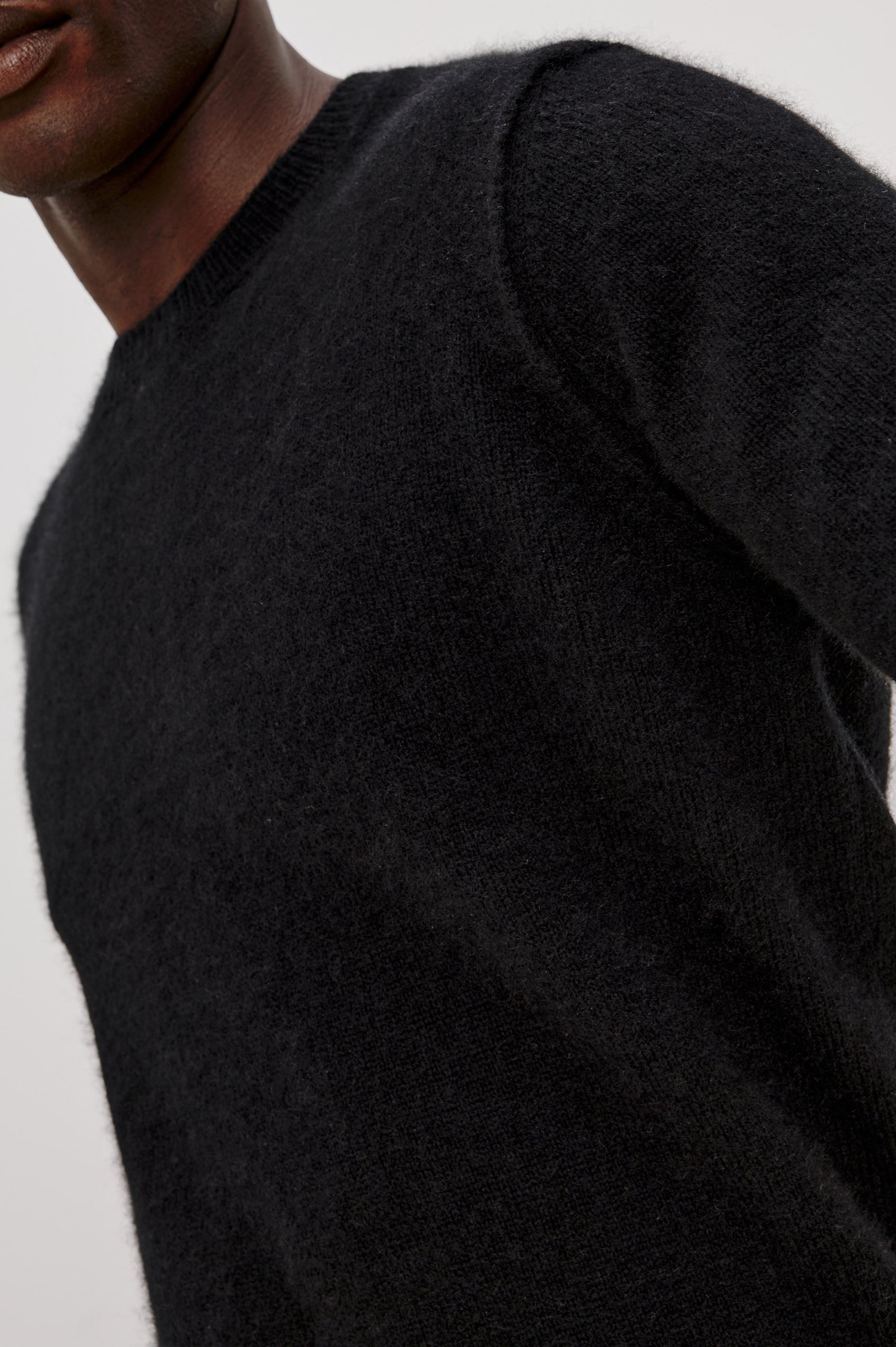 Laurent Sweater in Merino Wool Cashmere Blend With Relaxed Fit, Reversed Linking Seams at Arm Holes, and Long Sleeves in Black Colorway - Upper Body Front View Featured on Model