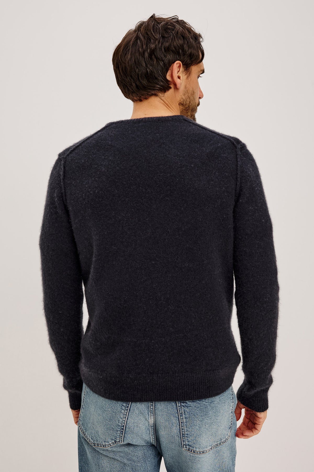 Laurent Crewneck Sweater in Wool Blend With Dropped Shoulders With Linking Stitch Detailing and Long Sleeves in Midnight Colorway - Upper Body Back View Featured on Model.