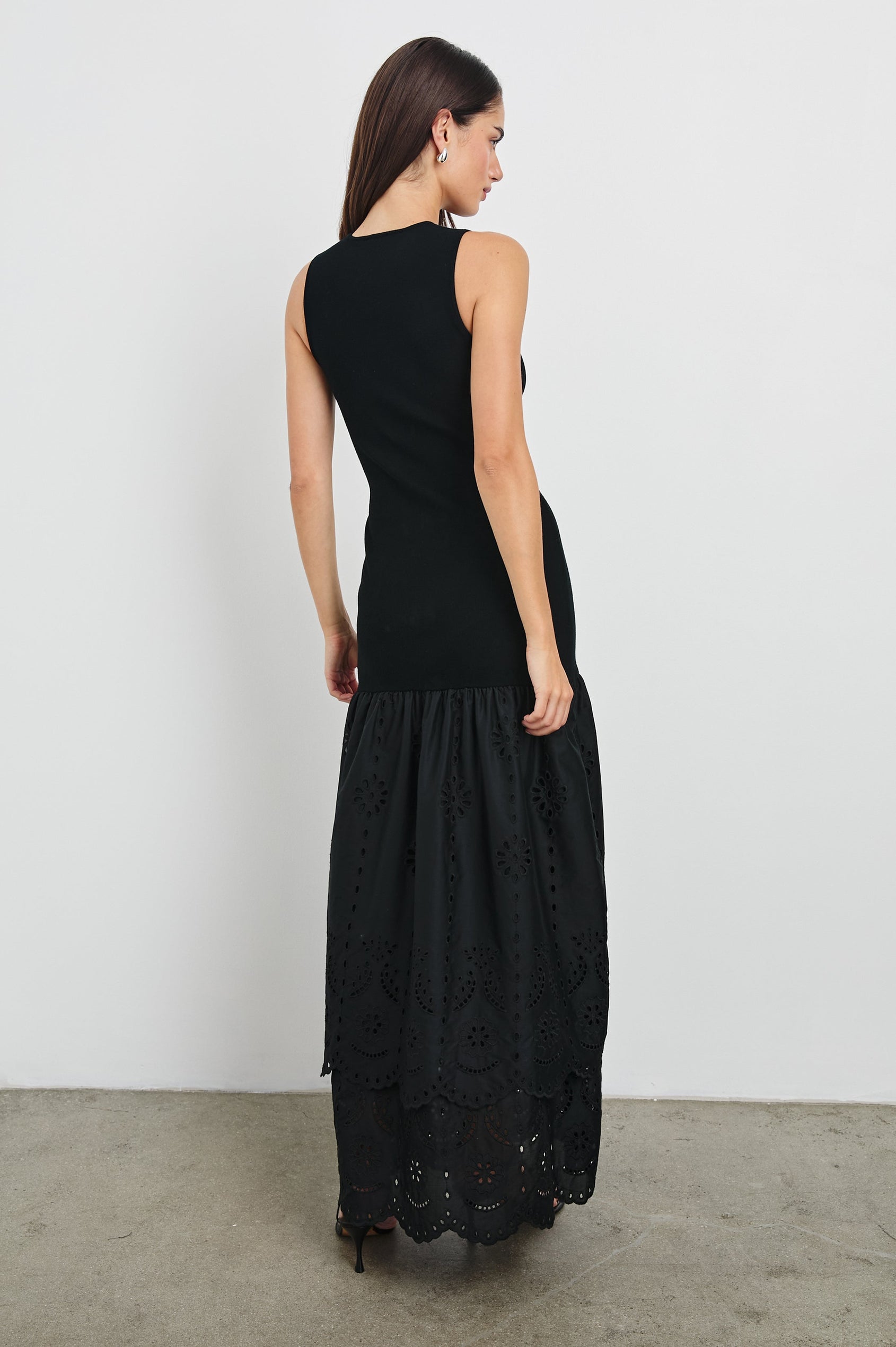 Lavina Crew Neck Tank Maxi Dress with Body Con Fitted Top Half and an Gathered Contrast Fabric Skirt with Embroidered Scallop Two Tier Hem in Black Colorway. Back View Shown on Model.