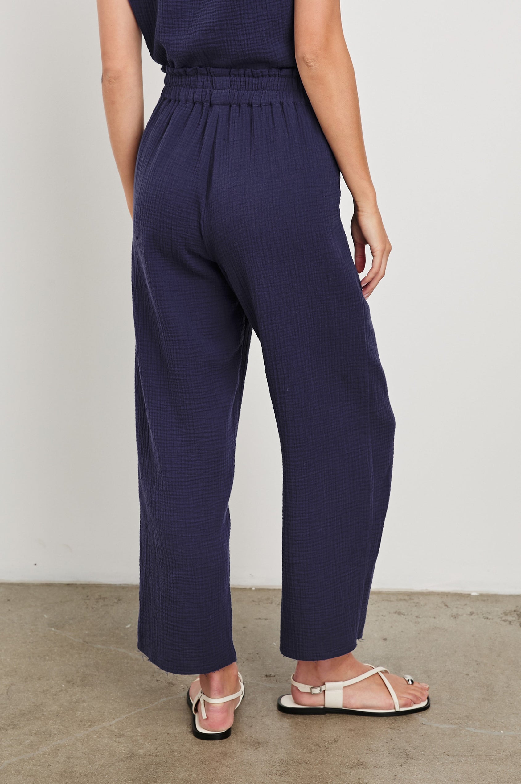 Leon Crop Cotton Gauze Pant With Hemline Slit And Elastic Waist In Colorway Admiral Blue - Back View Featured On Model