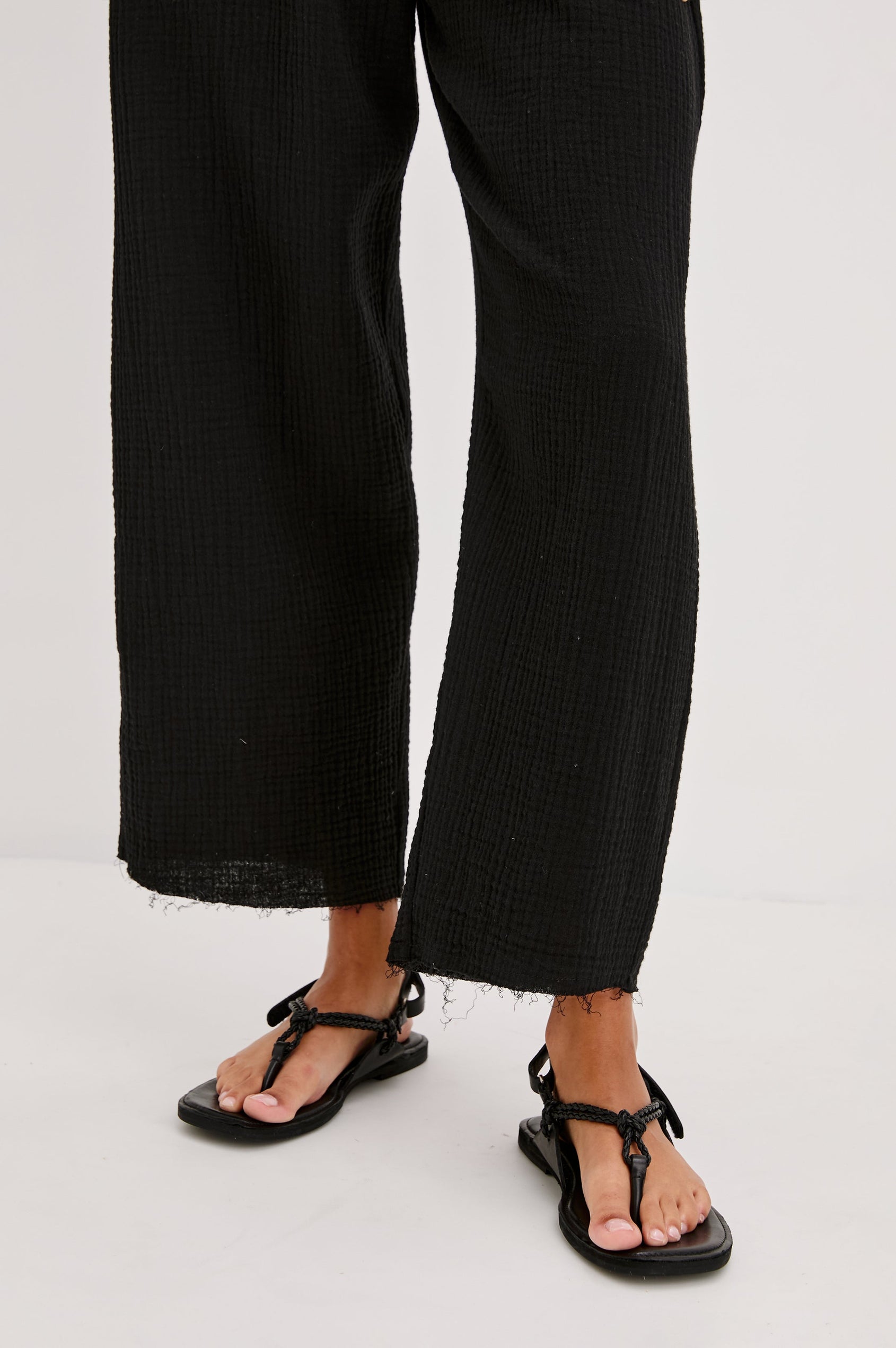 Leon Crop Cotton Gauze Pant With Hemline Slit And Elastic Waist In Colorway Black - Front Detail View Featured On Model