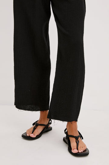 Leon Crop Cotton Gauze Pant With Hemline Slit And Elastic Waist In Colorway Black - Front Detail View Featured On Model