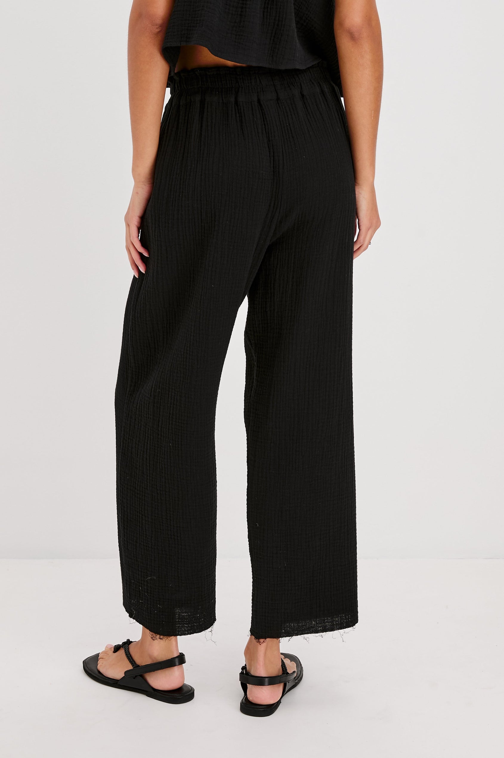 Leon Crop Cotton Gauze Pant With Hemline Slit And Elastic Waist In Colorway Black - Back View Featured On Model