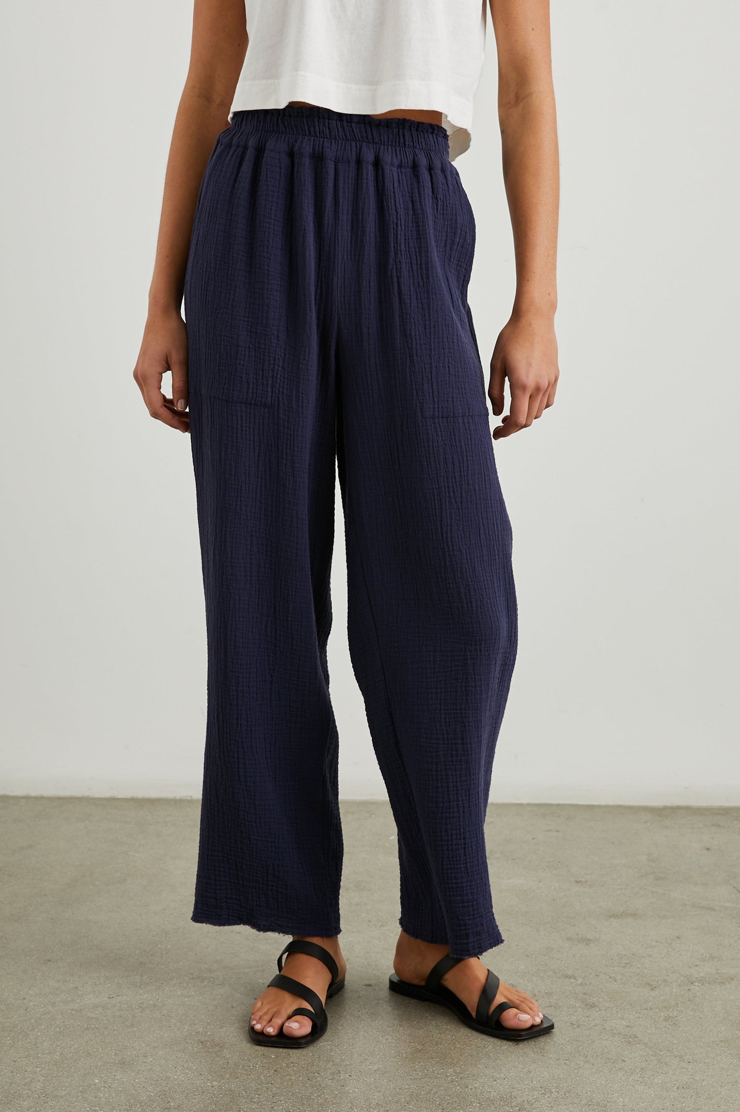 Leon Crop Pant with a Smocked Waistband and Two Front Seam Pockets in Navy Colorway - Front View Featured on Model