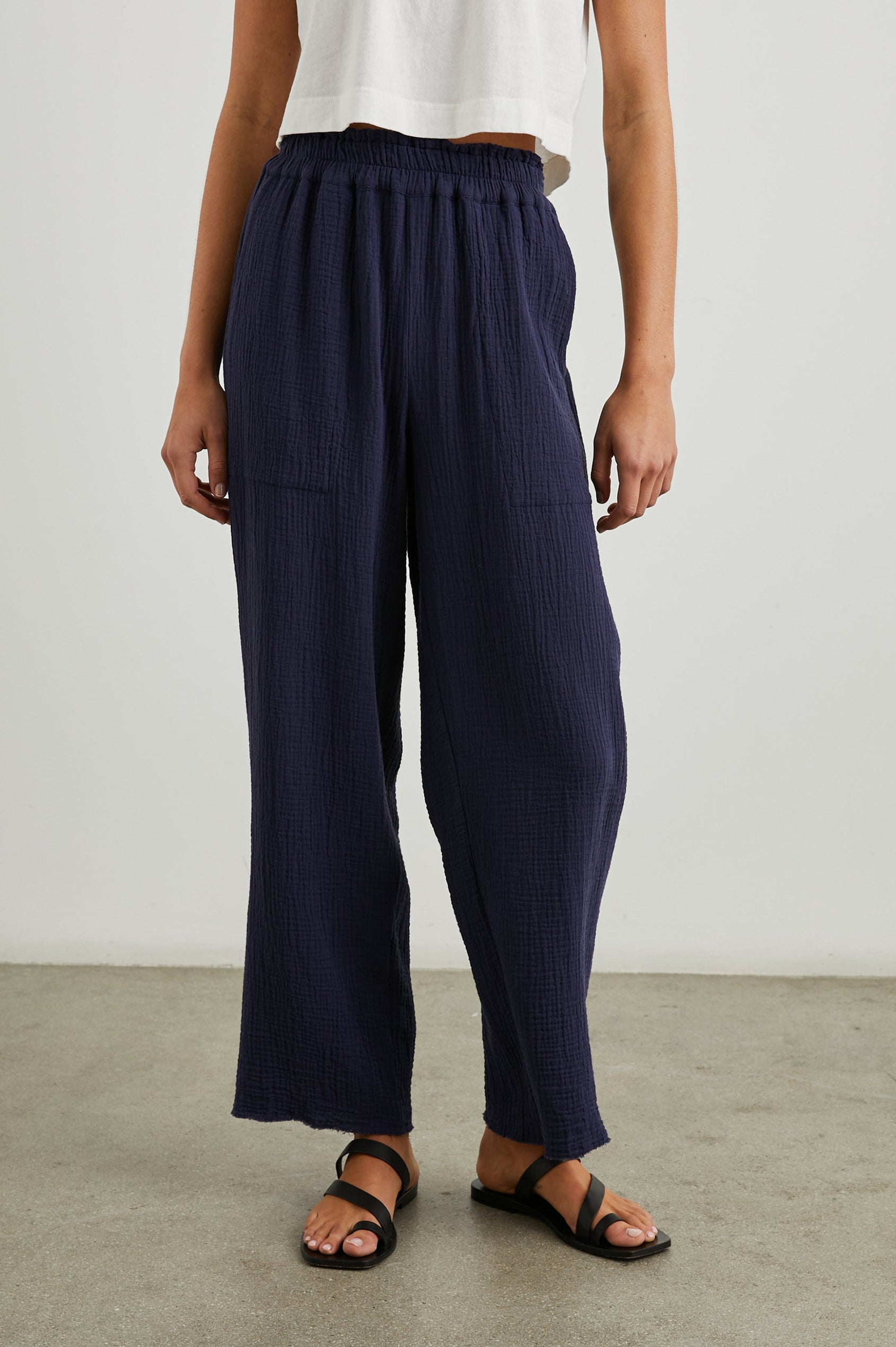 Leon Crop Pant with a Smocked Waistband and Two Front Seam Pockets in Navy Colorway - Front View Featured on Model
