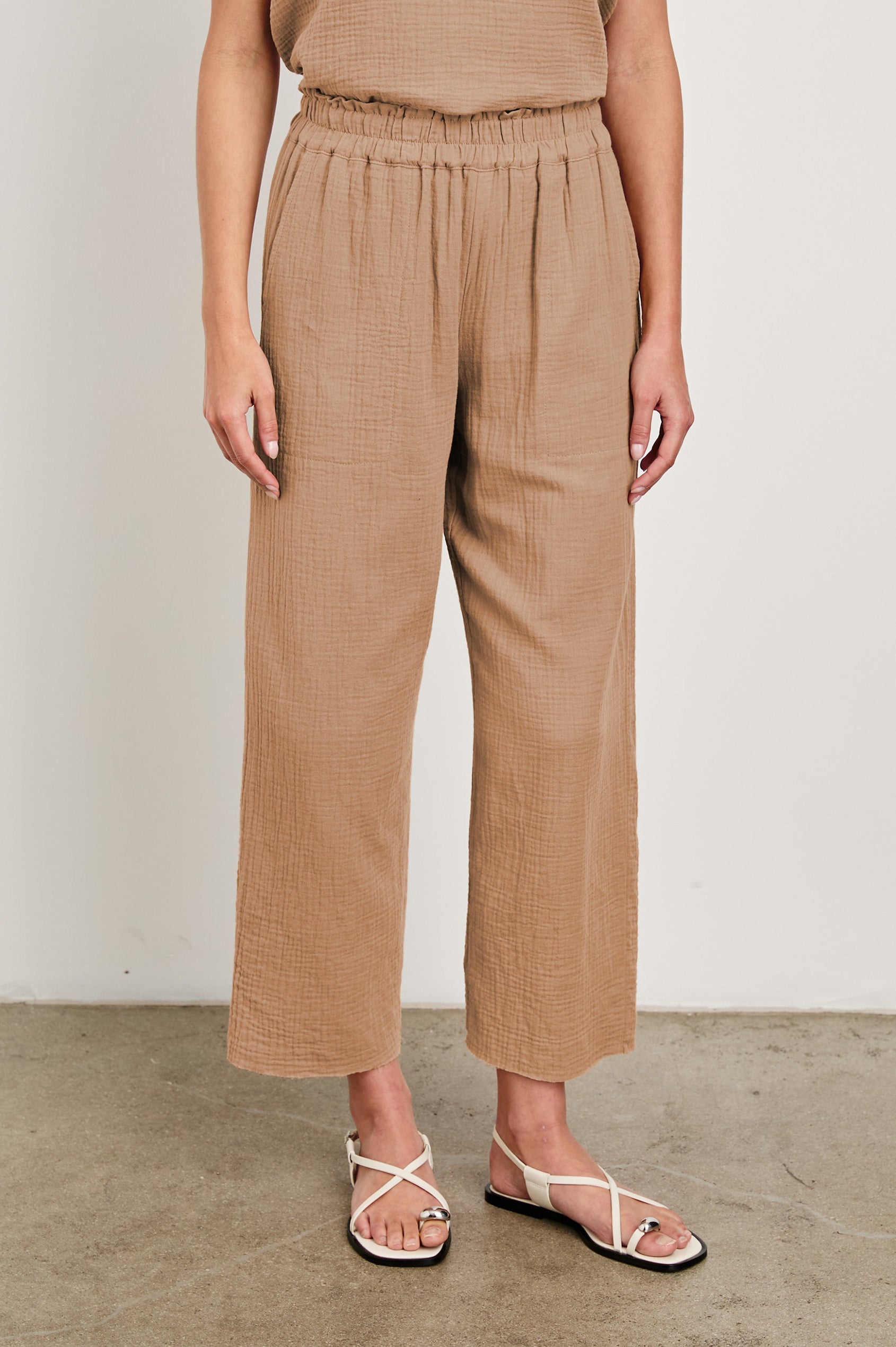 Leon Crop Cotton Gauze Pant With Hemline Slit And Elastic Waist In Colorway Taupe - Front View Featured On Model Shirt Tucked In