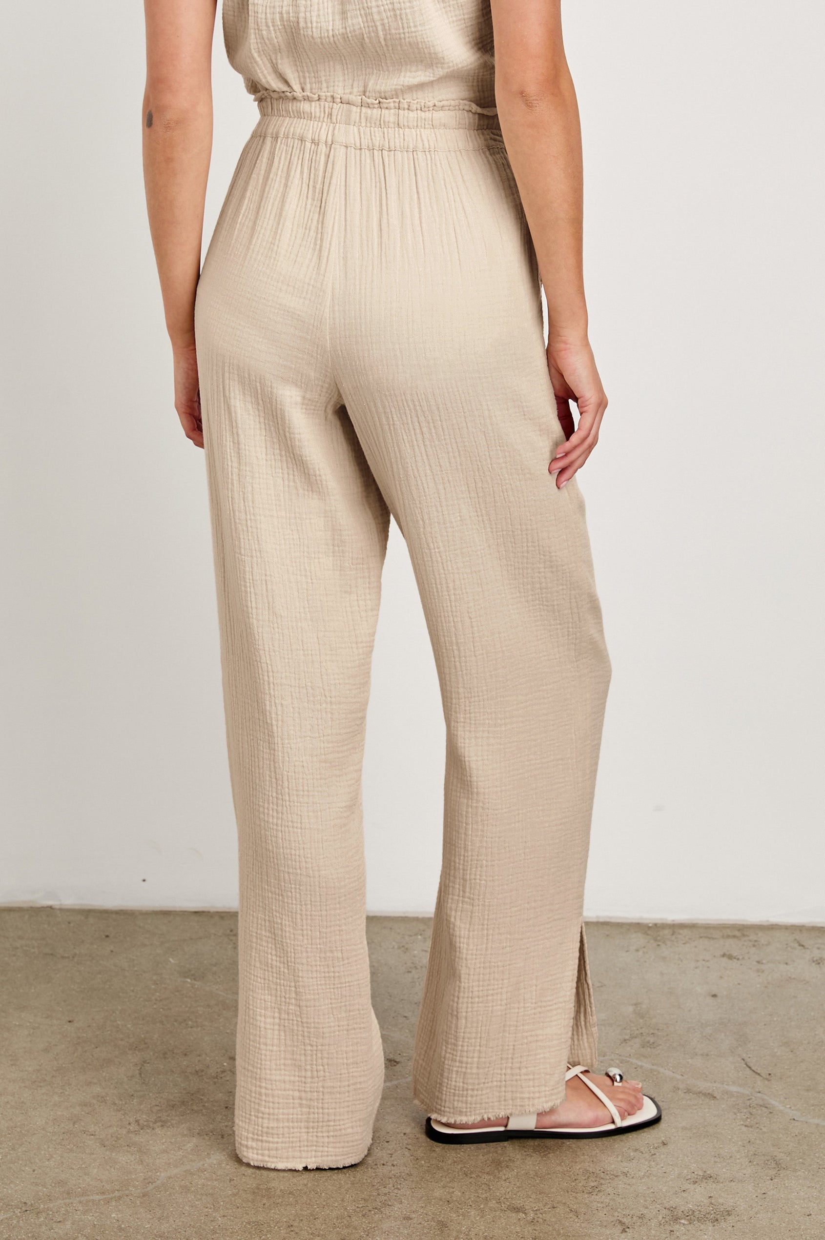 Leon Cotton Gauze Pant With Hemline Slit And Elastic Waist In Colorway Flax -  Back View Featured On Model