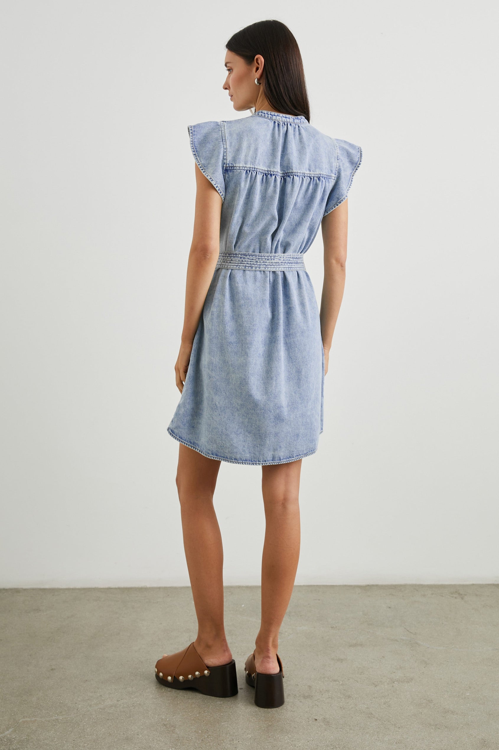 Letta Above-Knee Dress with Flutter Sleeves, Snaps down the Front, and a Belted Waist in Faded Indigo Colorway - Back Full Body View Featured on Model 