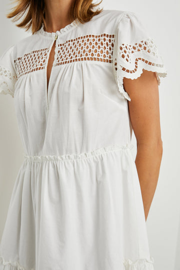 Lettie Short Sleeve Mini Dress with a Button Keyhole Neckline, a Tiered Skirt, and an Eyelet Design on the Yoke, Sleeves and Hem in White Colorway - Front View Featured on Model 