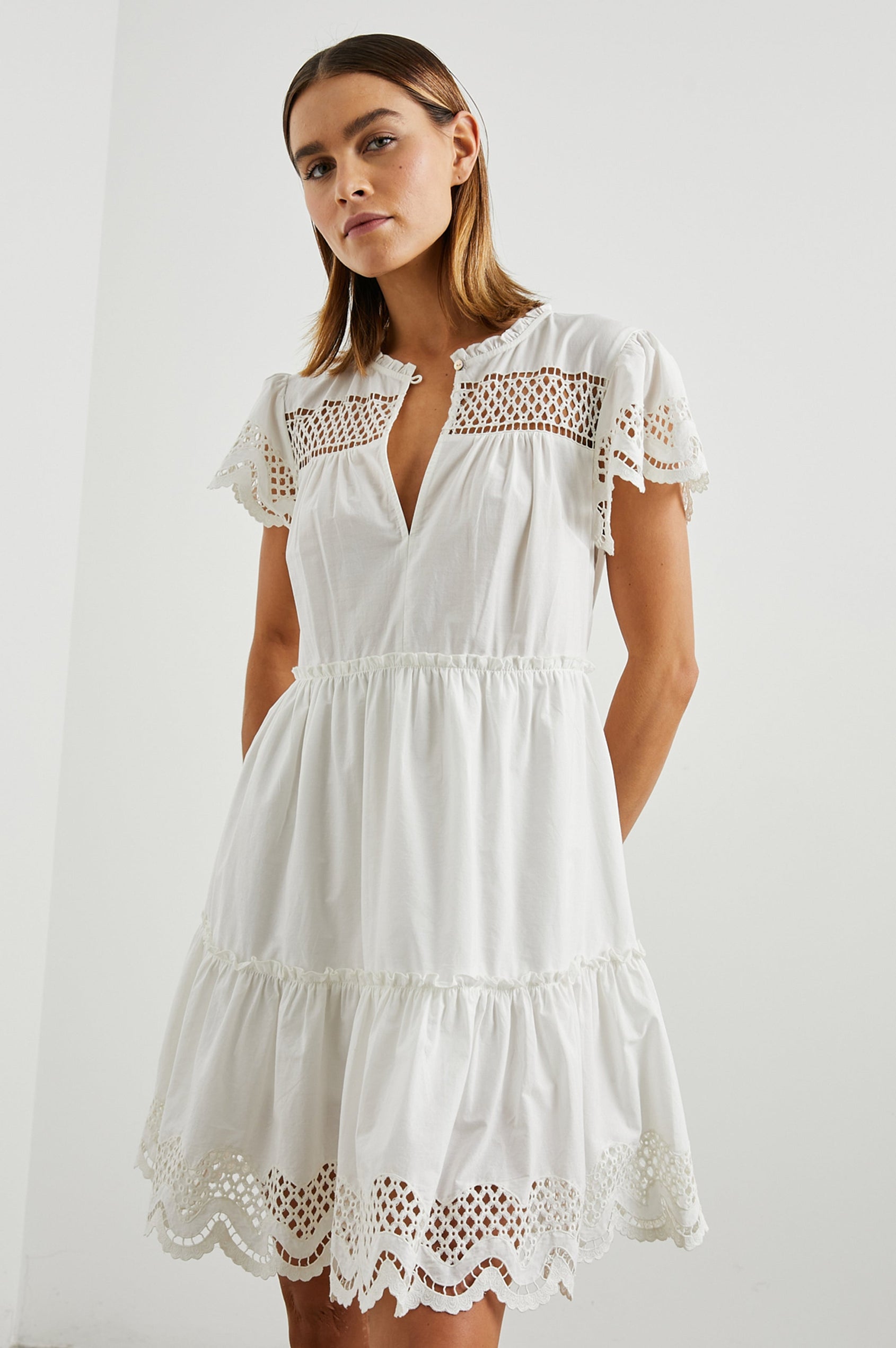 Lettie Short Sleeve Mini Dress with a Button Keyhole Neckline, a Tiered Skirt, and an Eyelet Design on the Yoke, Sleeves and Hem in White Colorway - Front View Featured on Model 