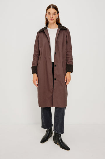 Full-length coat with a classic silhouette in Raisin Colorway. The coat is fully lined in plaid and finished with corduroy accents at the cuffs and collar for a heritage-inspired look. Front View featured on Model.