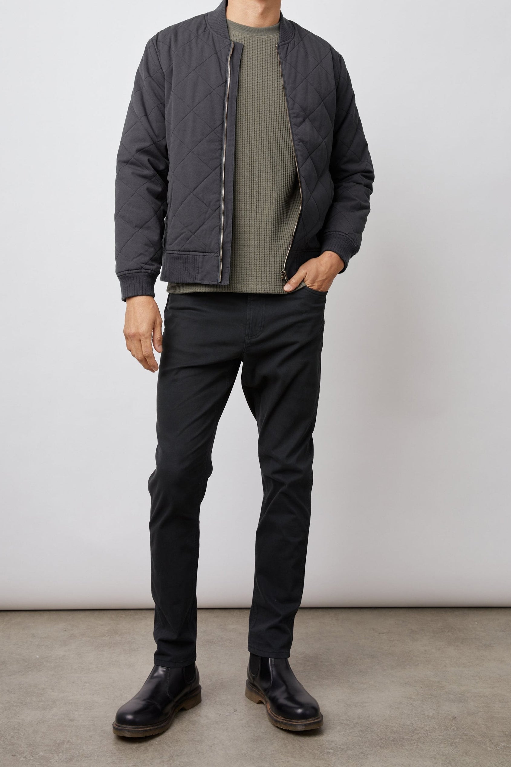 Peninsula Jacket with Zip Closure, Two Front Pockets, an Inner Zippered Pocket, a Quilted Pattern and Ribbed Trim in Washed Black Colorway - Front Full Body View Featured on Model