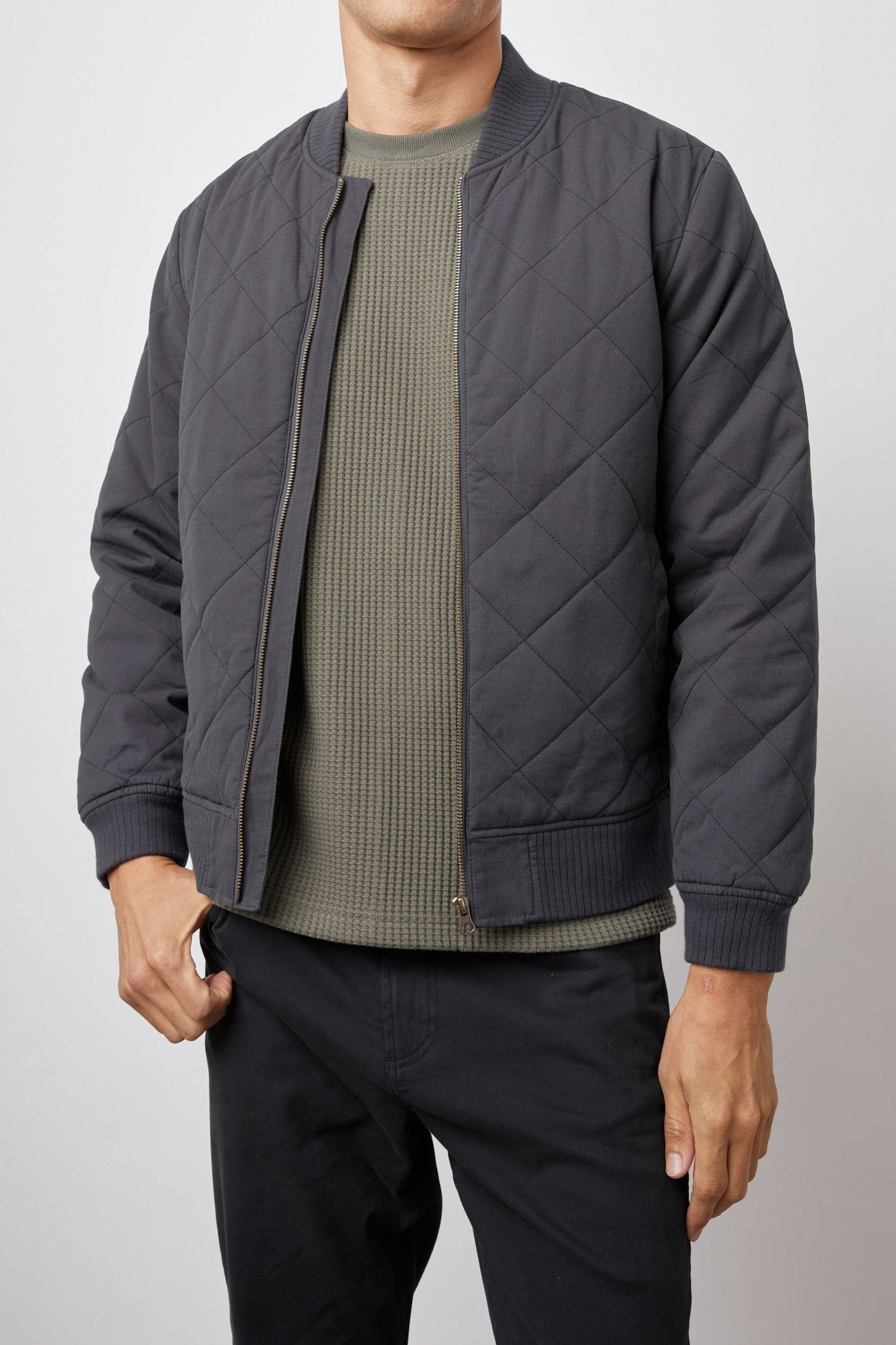Peninsula Jacket with Zip Closure, Two Front Pockets, an Inner Zippered Pocket, a Quilted Pattern and Ribbed Trim in Washed Black Colorway - Front View Featured on Model